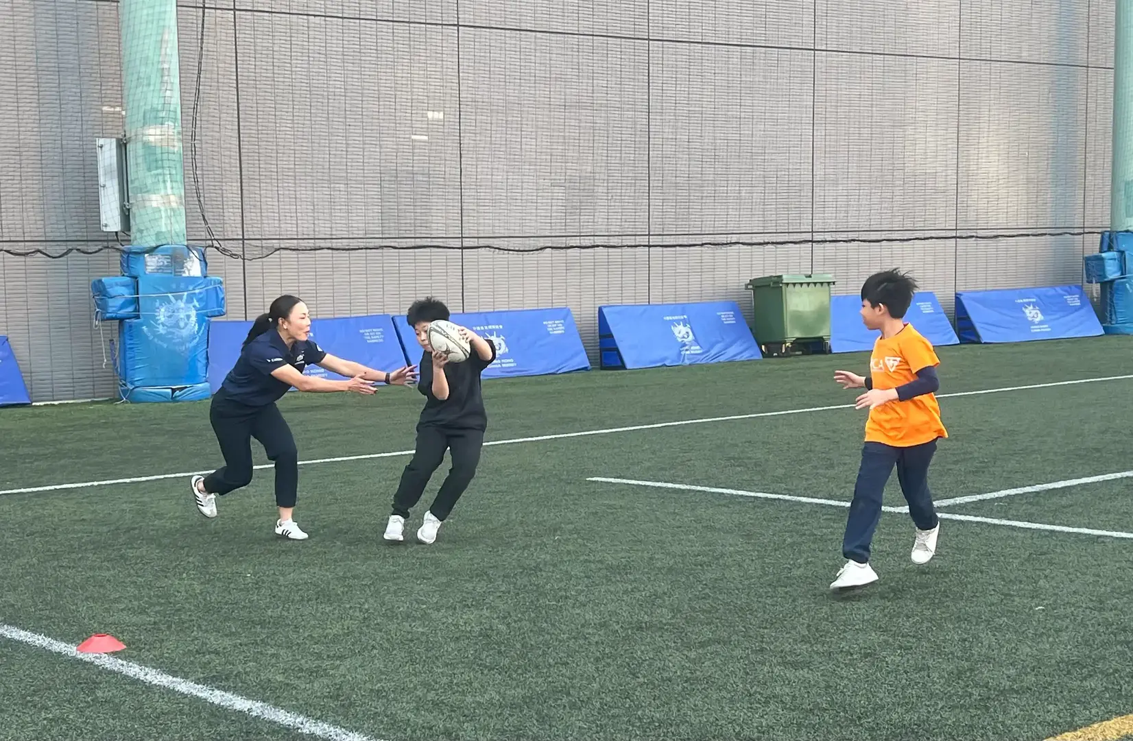 香港橄榄球代表队运动员蓝嘉敏于2025年1月15日在中华基督教青年会小学指导学生运球
