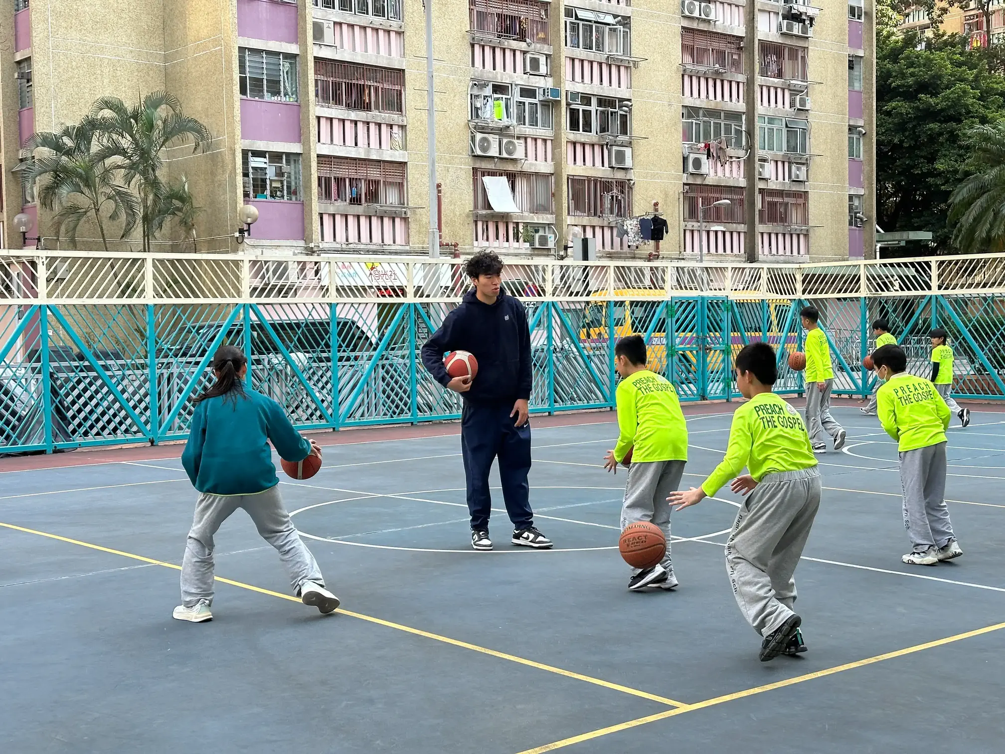 香港篮球代表队运动员叶耀邦于2025年1月10日与浸信会天虹小学学生合影留念