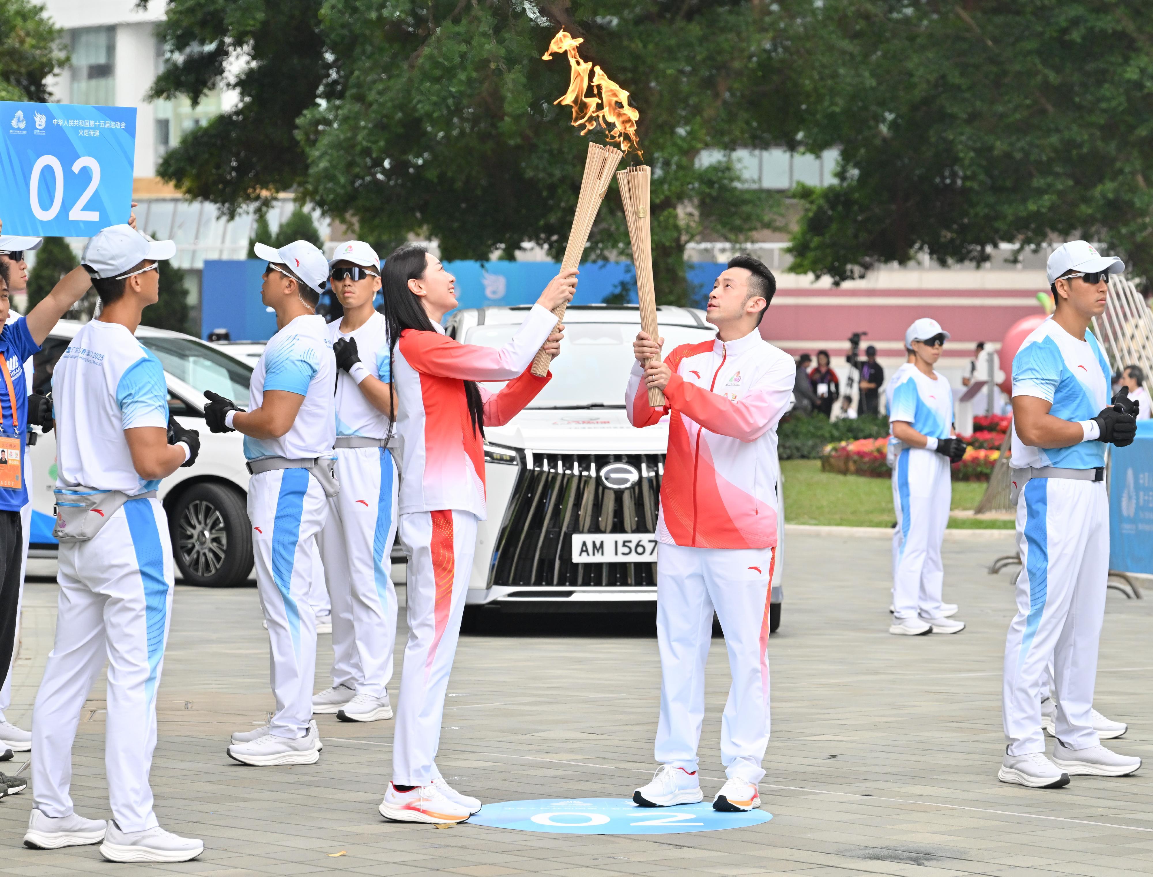 黃鎮廷（右）把火種傳給孫一文（左）。