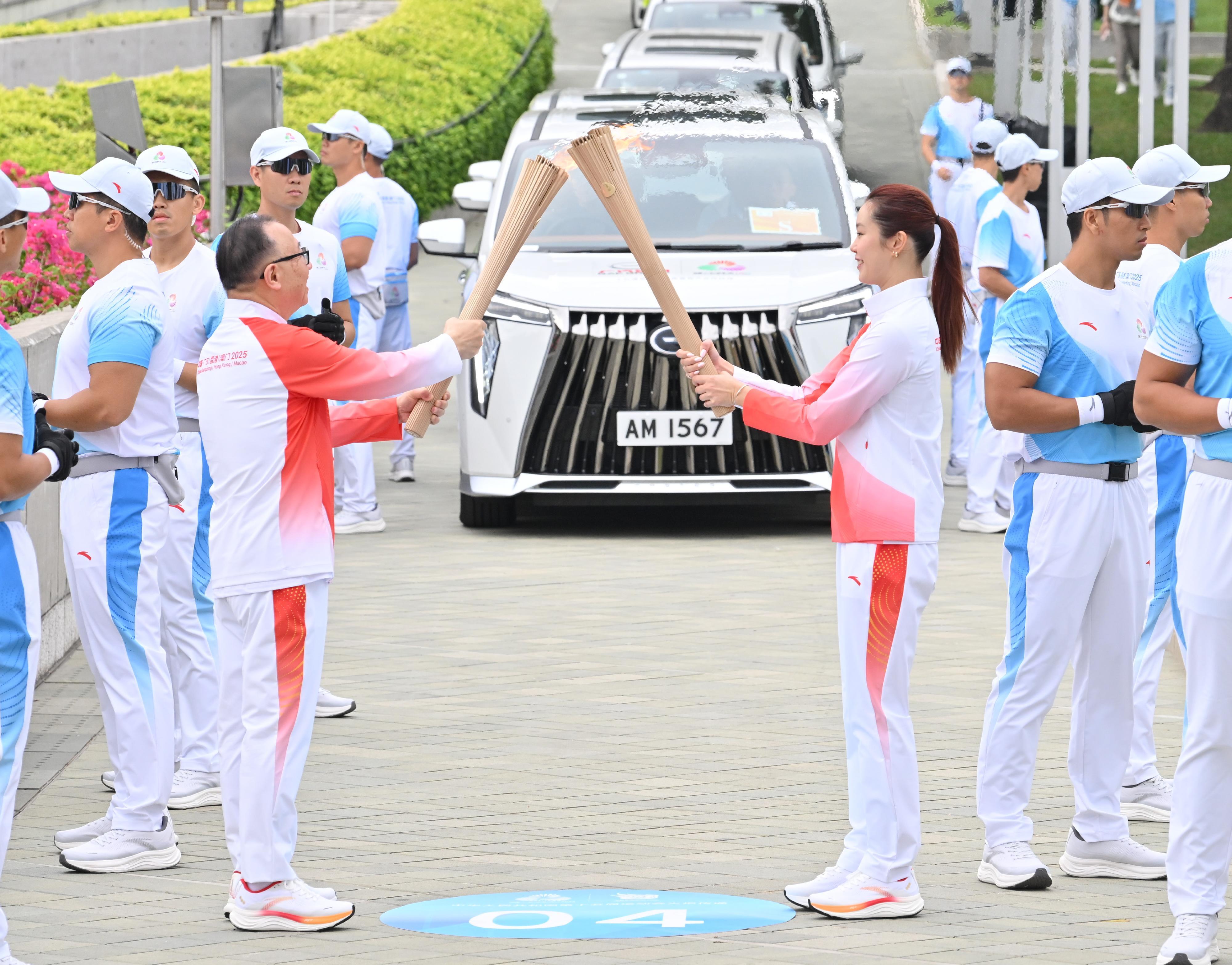 歐鎧淳（右）把火種傳給廖長江（左）。