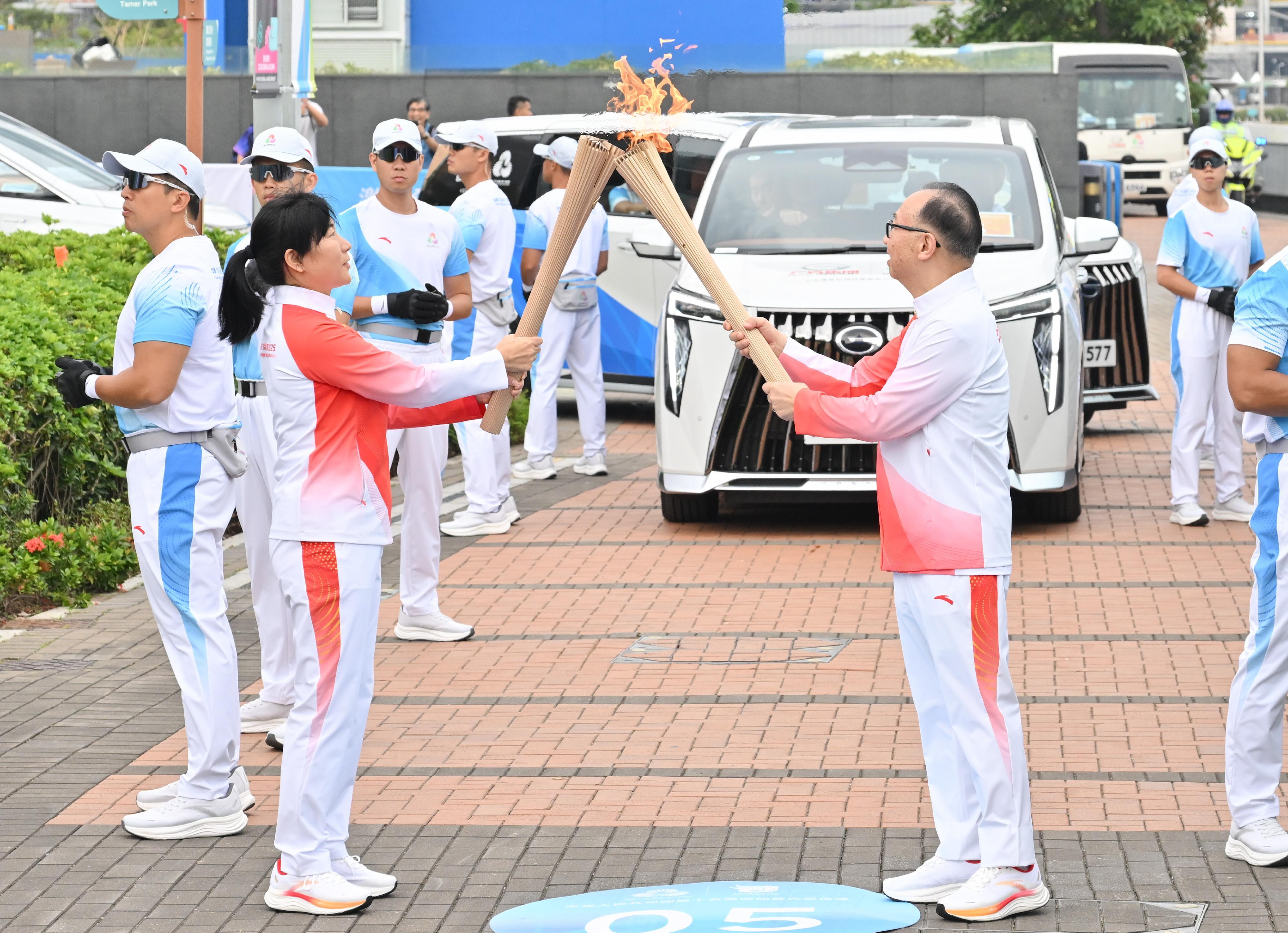 廖長江（右）把火種傳給汪琳（左）。