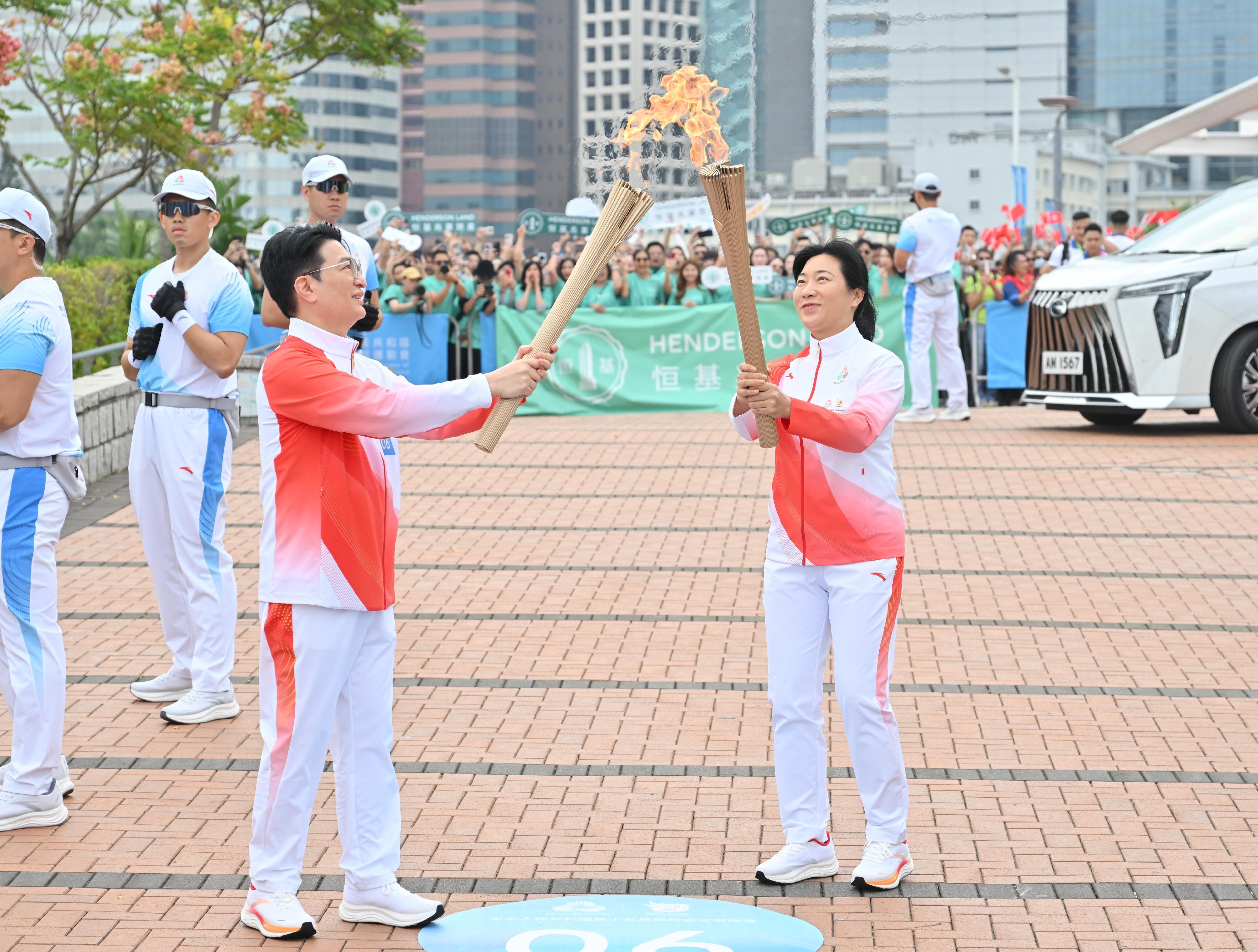 汪琳（右）把火種傳給李家誠（左）。