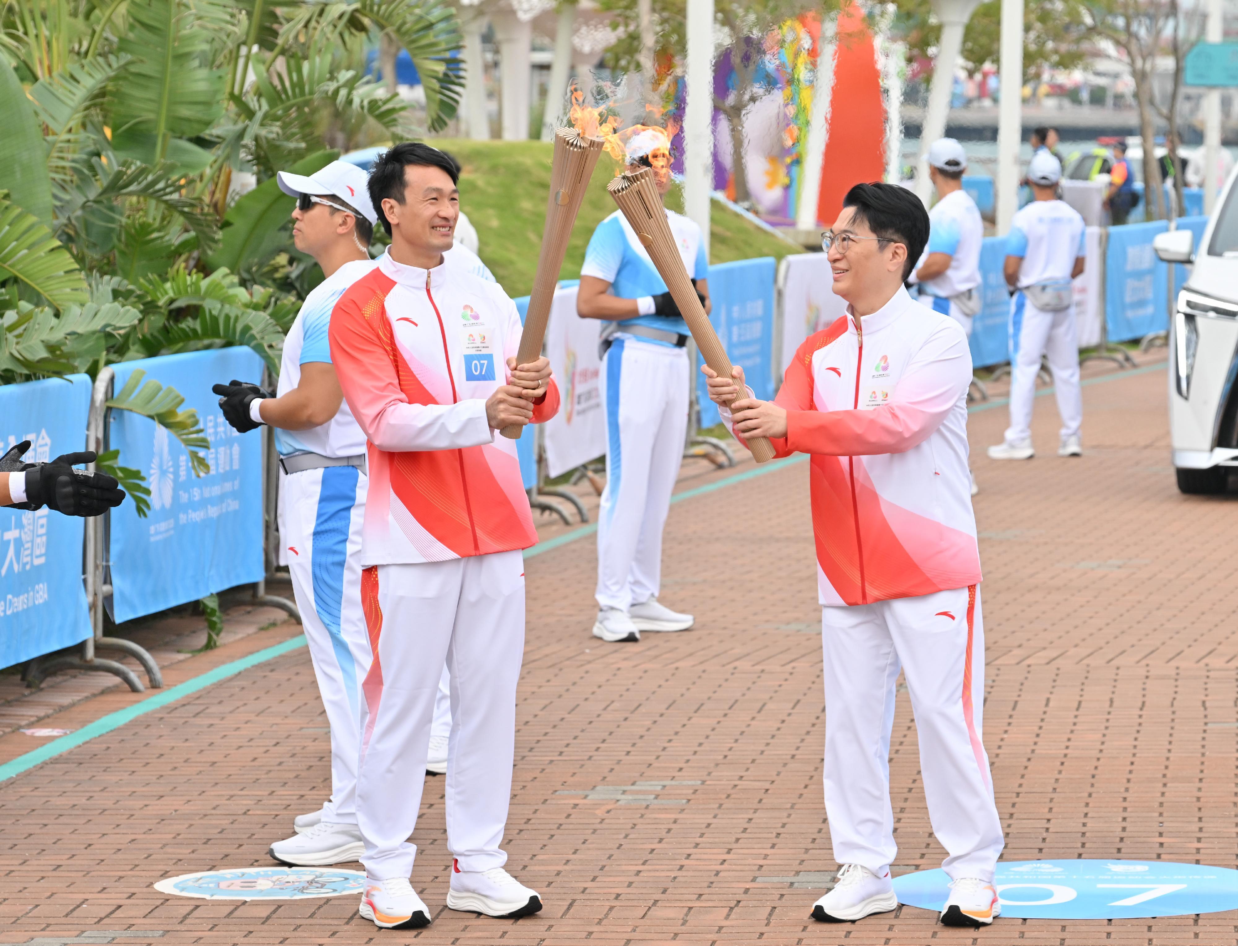 李家誠（右）把火種傳給姚錦成（左）。