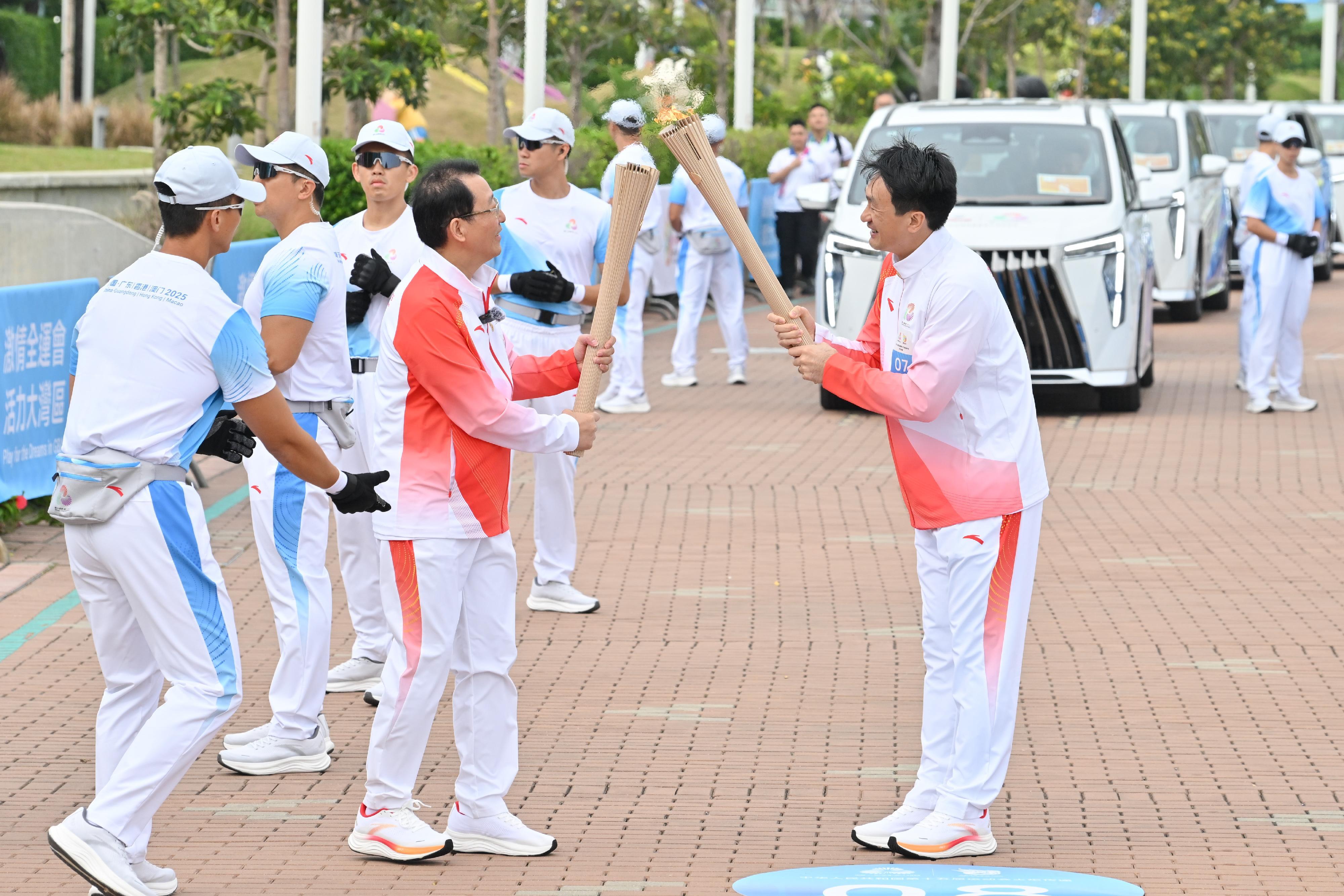 姚錦成（右）把火種傳給馮興亞（左）。