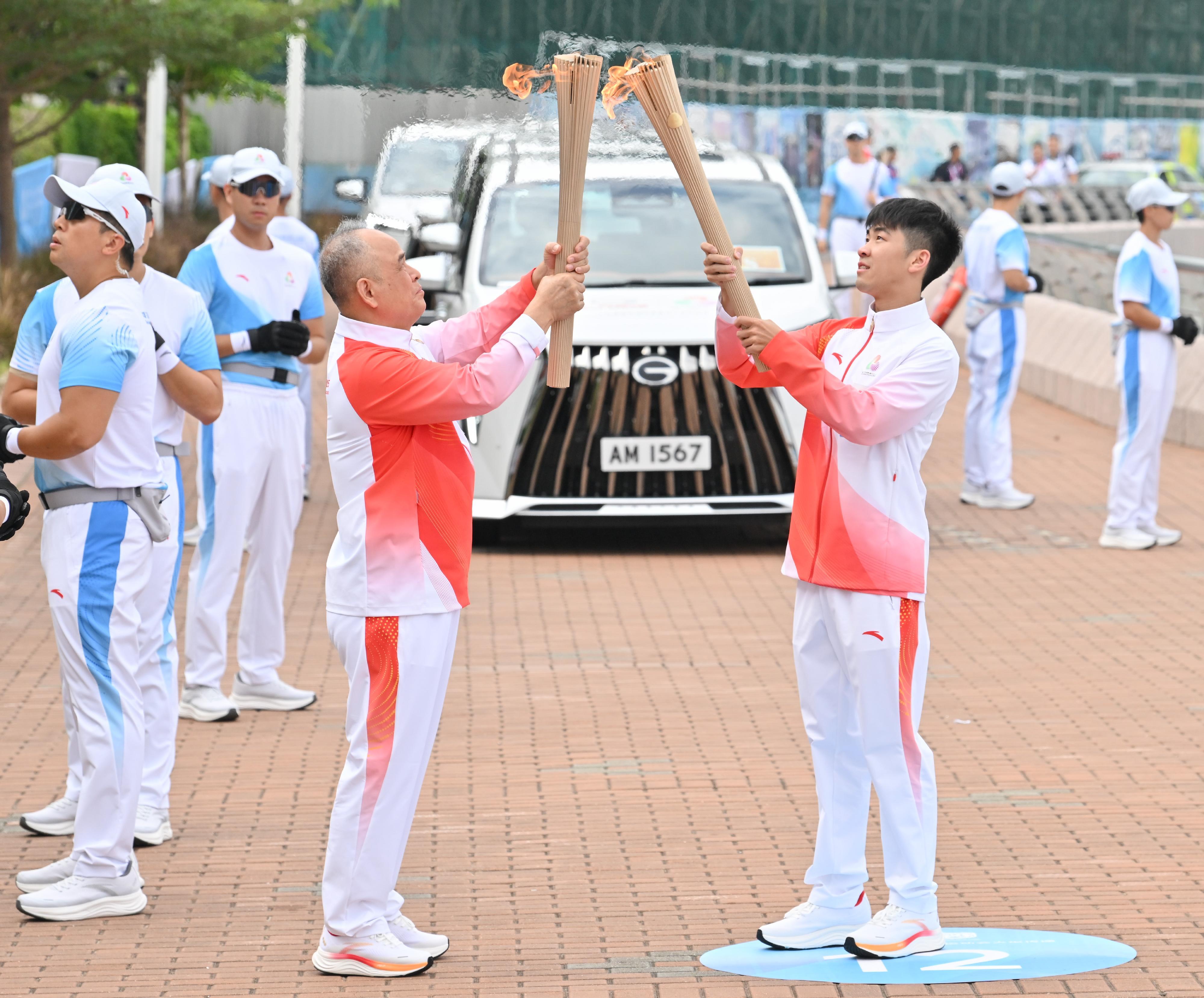 葉德朗（右）把火種傳給易桂平（左）。