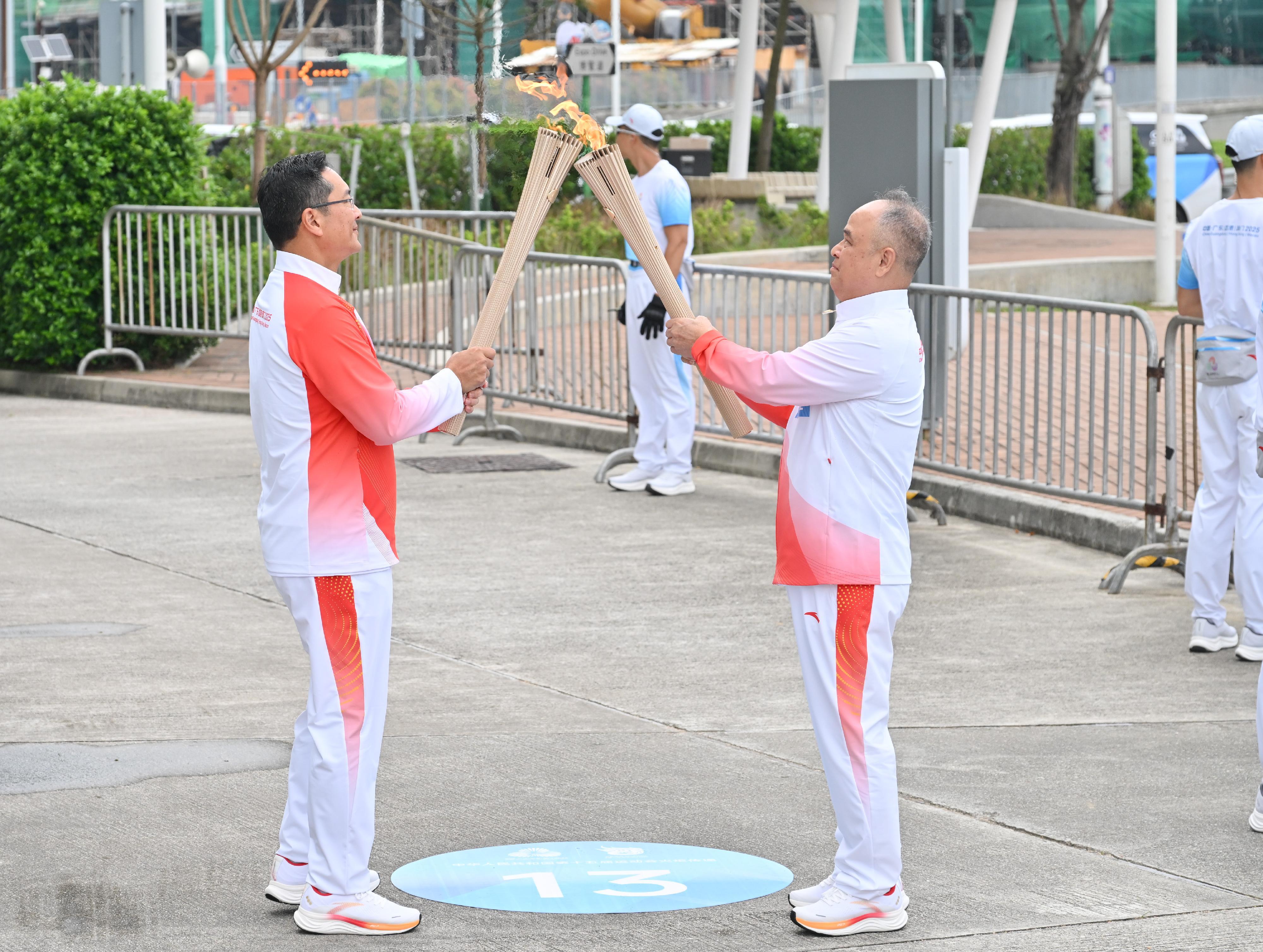 易桂平（右）把火種傳給林詩鍵（左）。