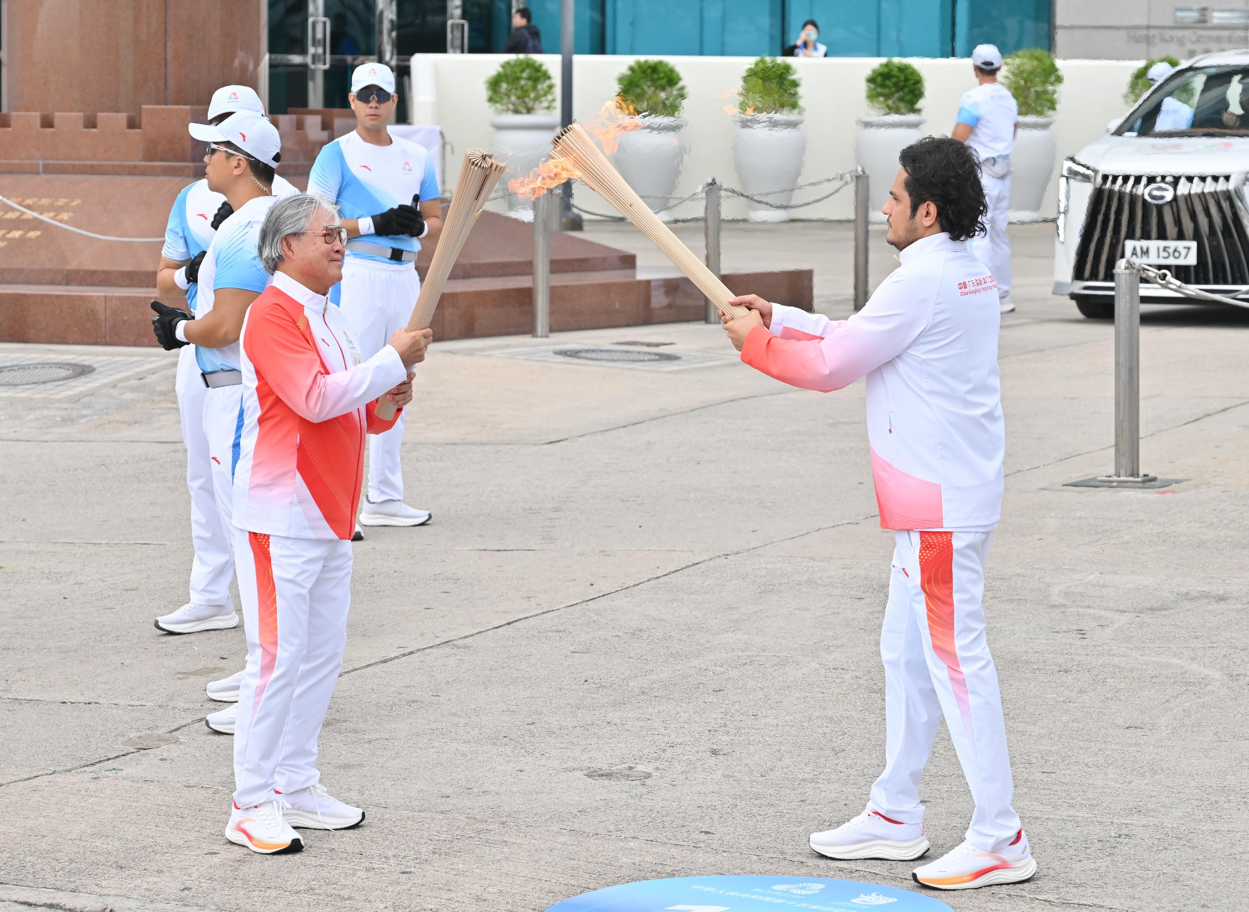 利哲宏（右）把火種傳給霍震霆（左）。