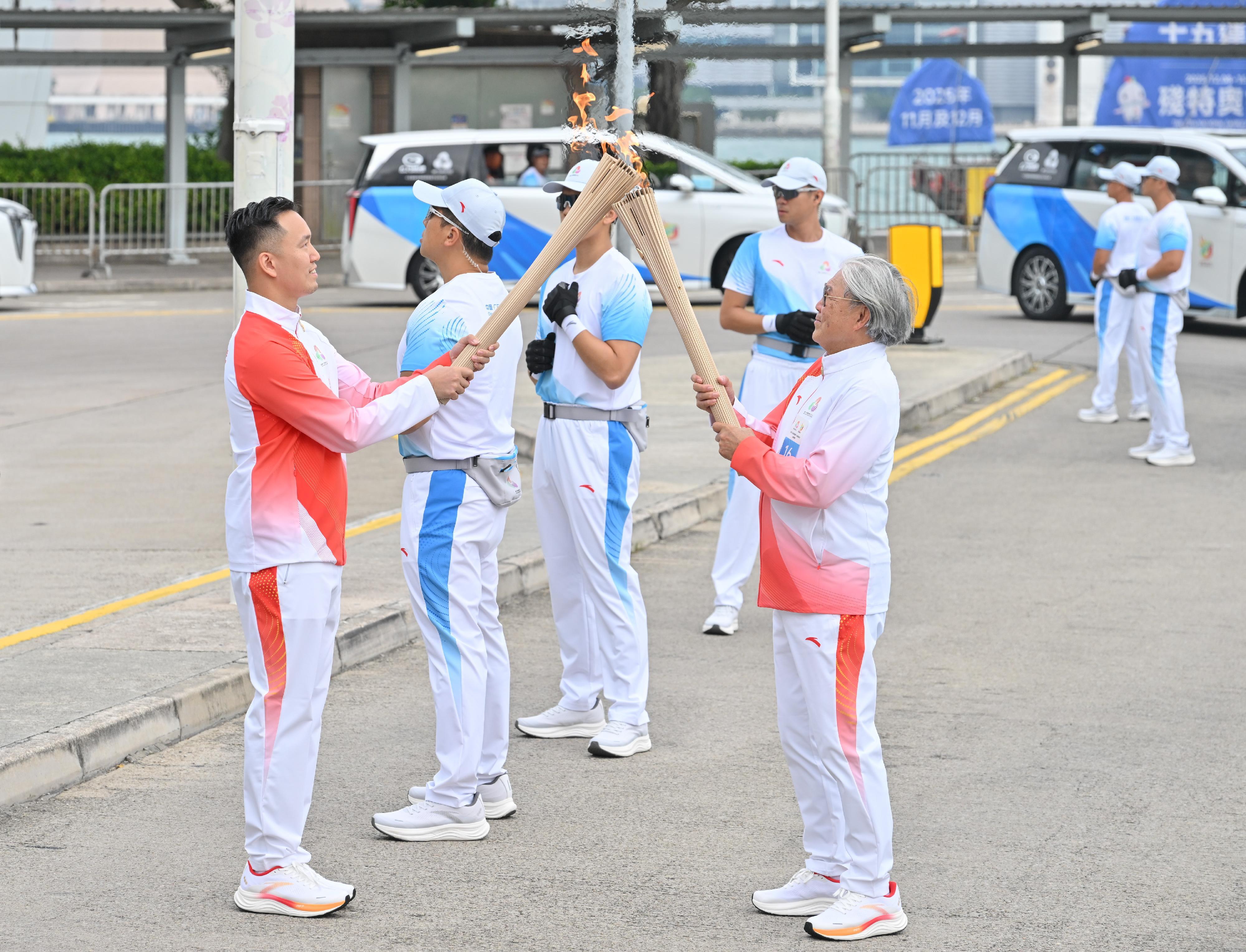 霍震霆（右）把火種傳給李振豪（左）。