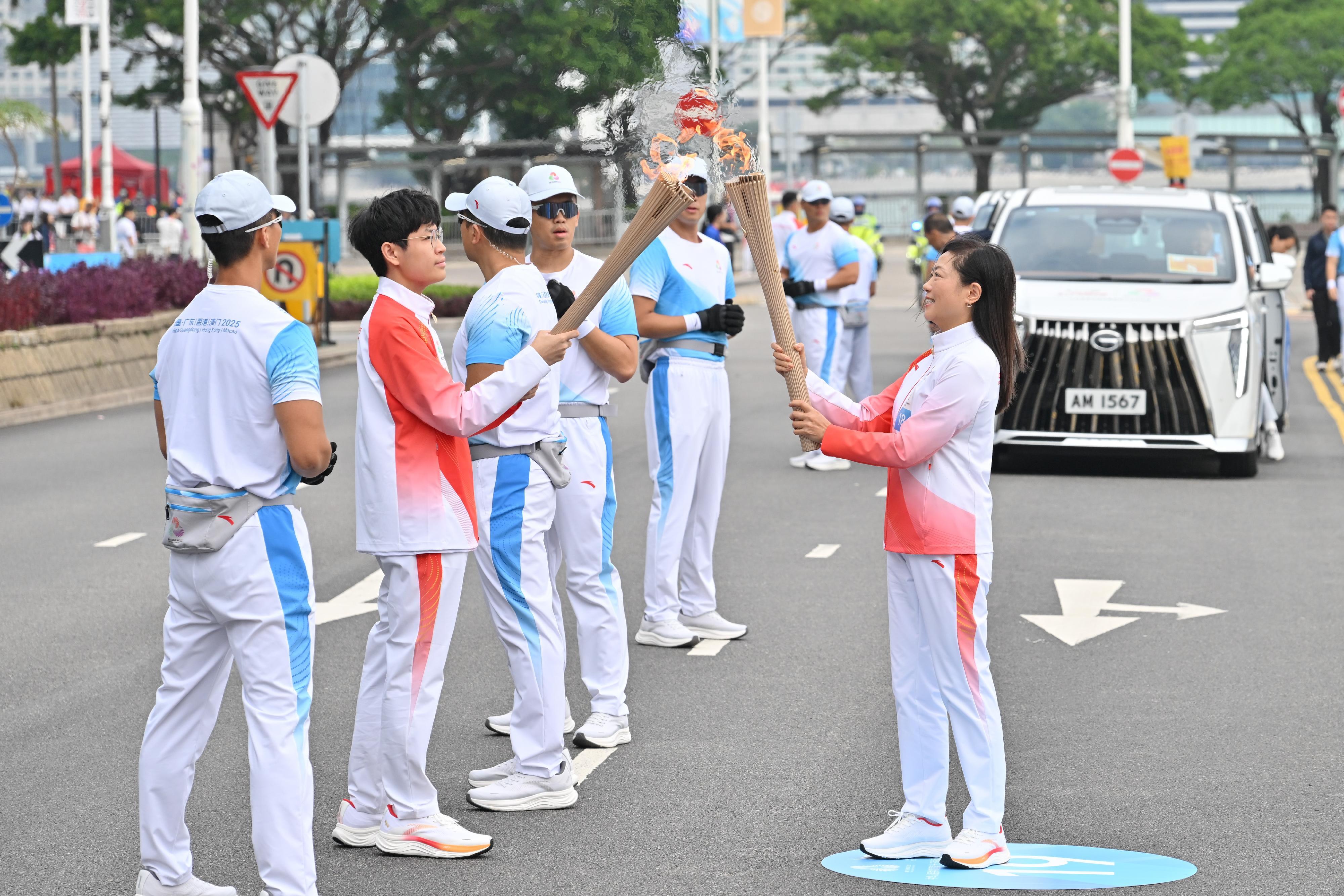 王佩兒（右）把火種傳給胡瑋琛（左）。