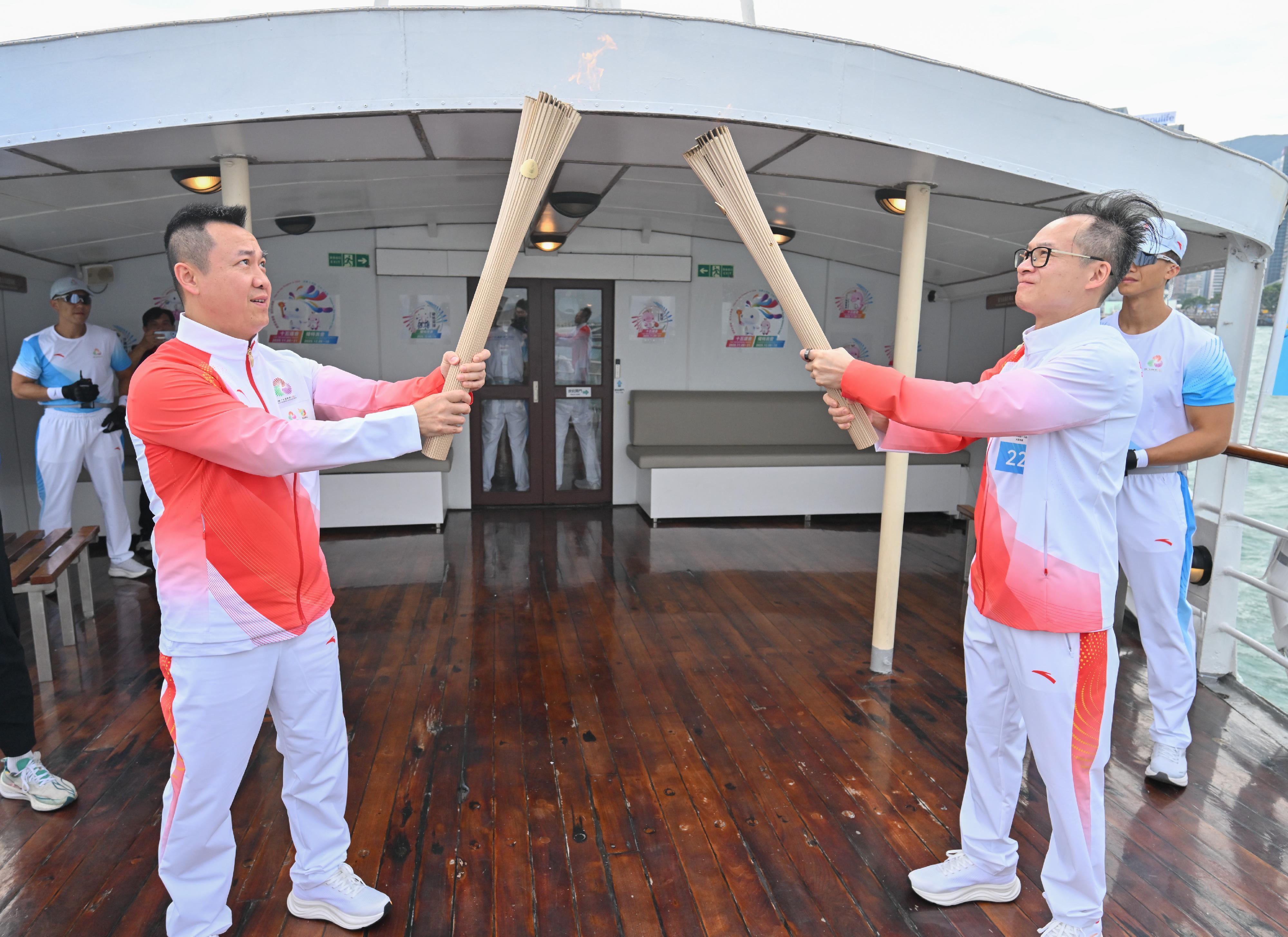 周潤宏（右）把火種傳給李靜（左）。