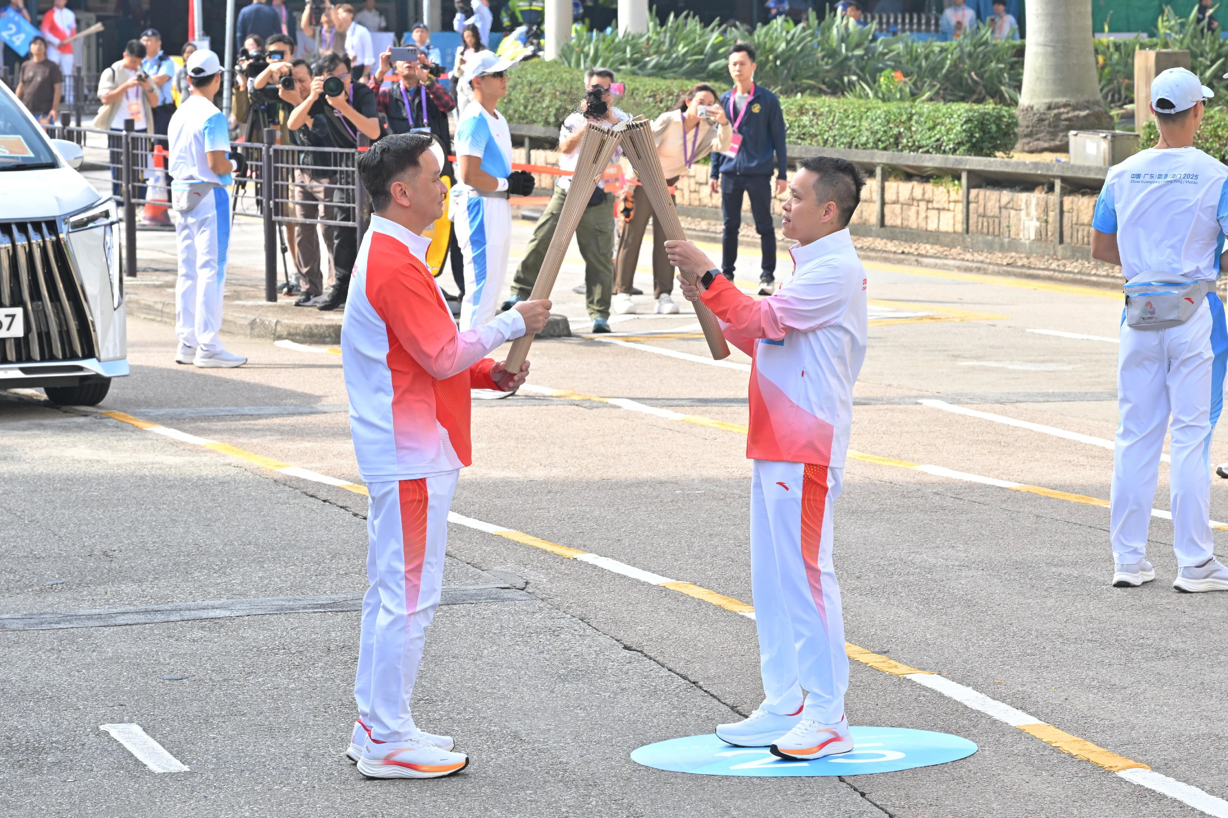 楊晉瑋（右）把火種傳給容樹恒（左）。