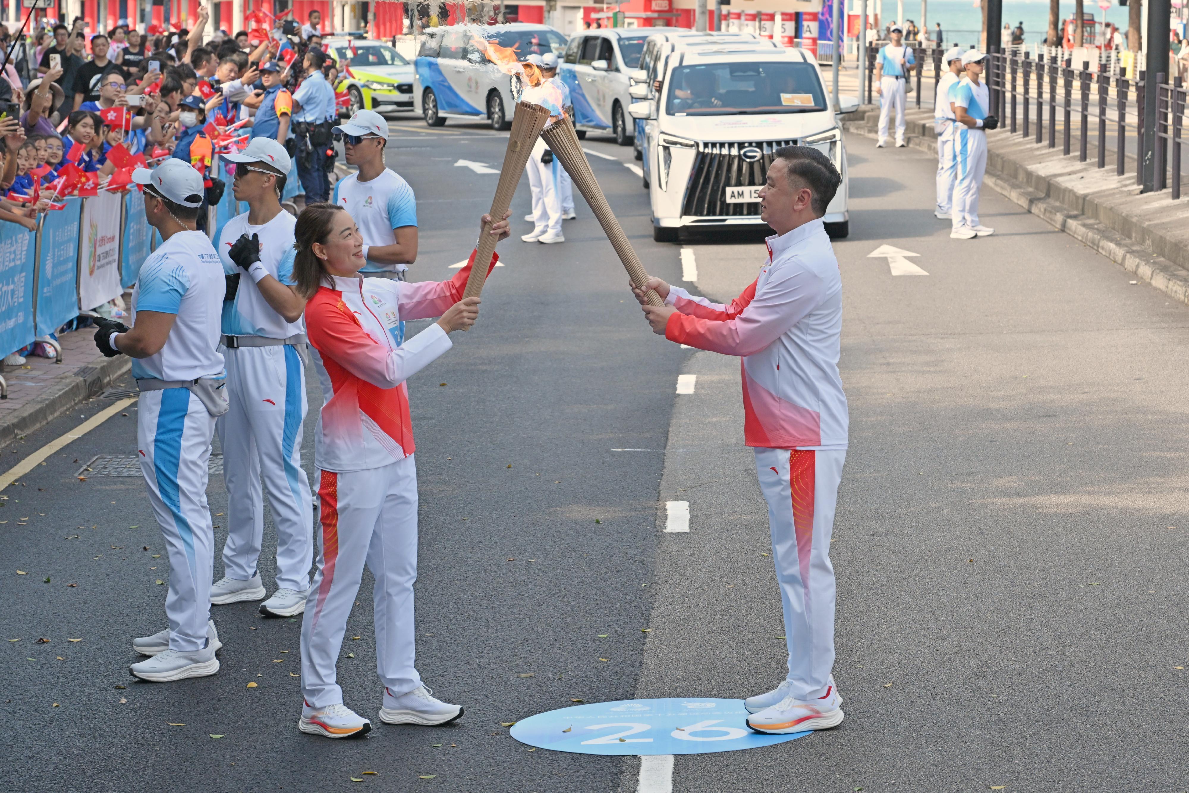 容樹恒（右）把火種傳給李嘉文（左）。
