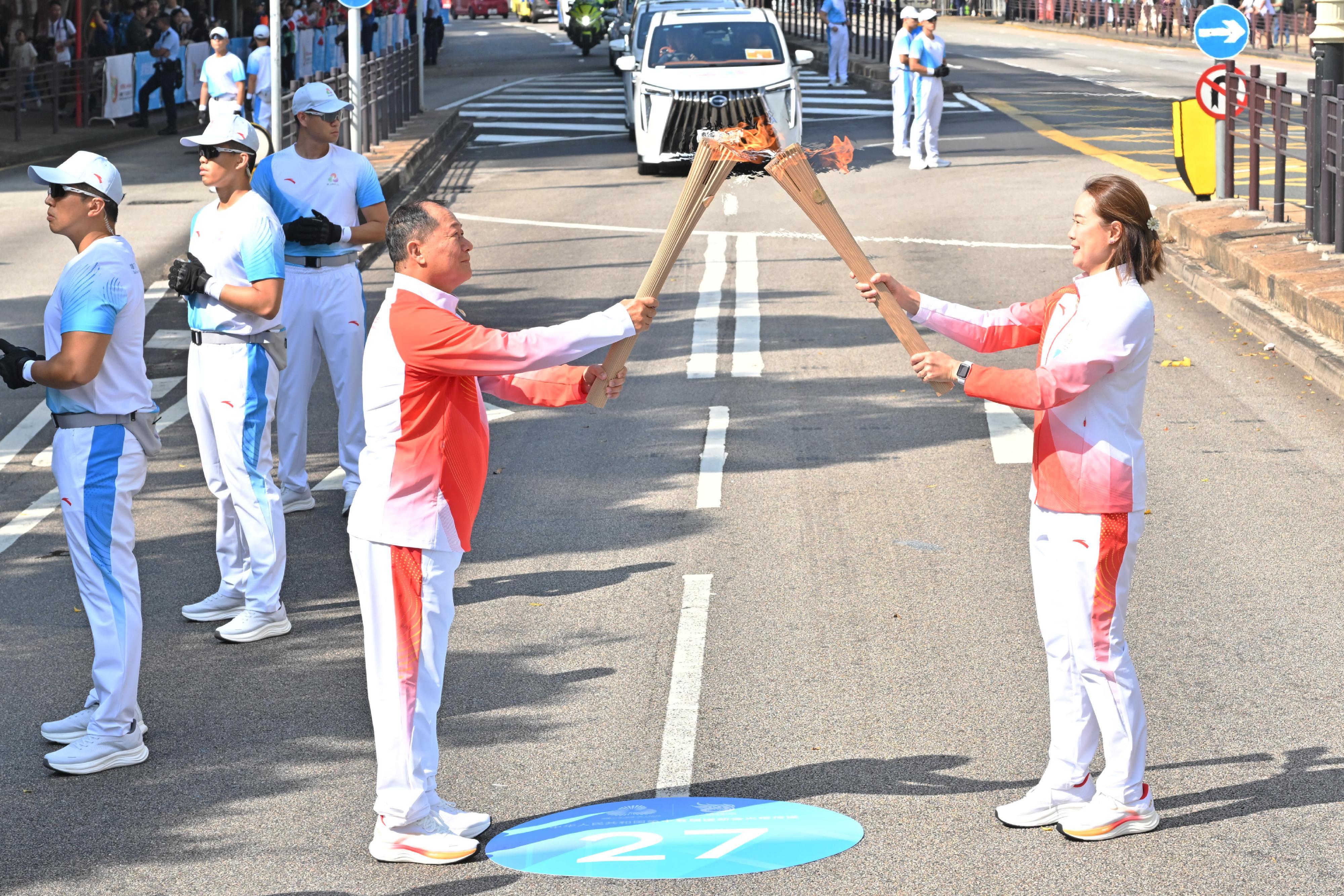 李嘉文（右）把火種傳給張偉良（左）。