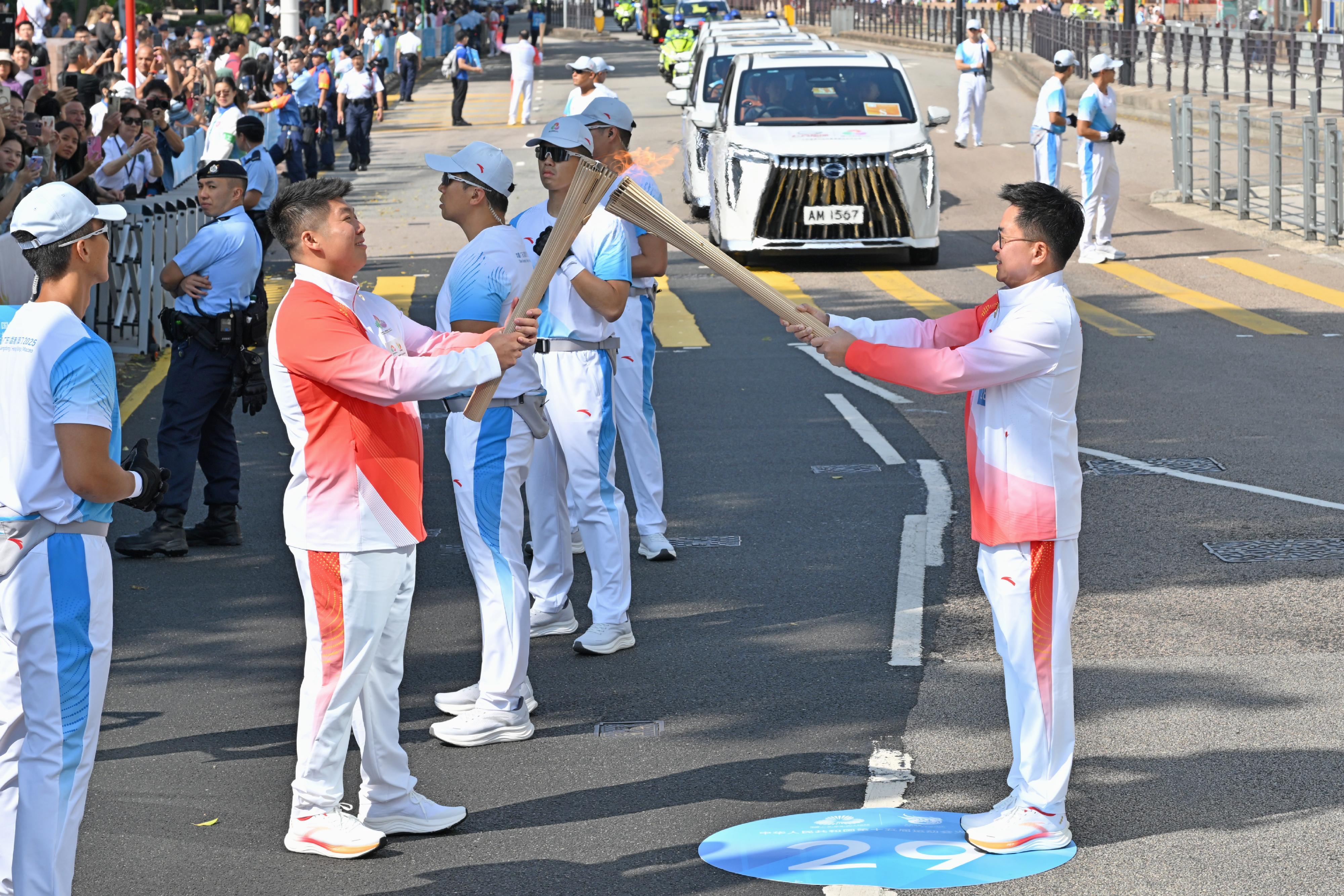 林漢平（右）把火種傳給黃焯添（左）。