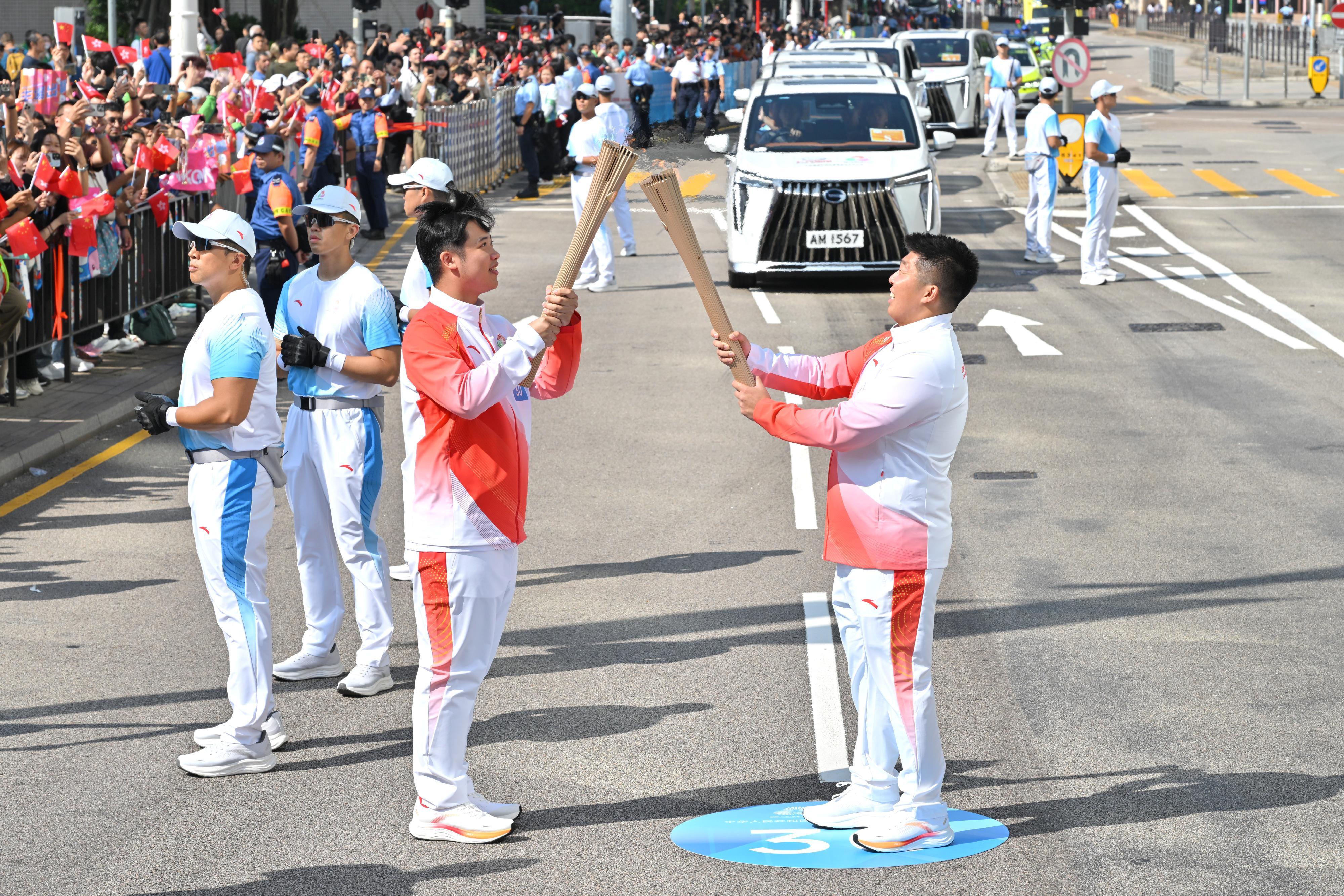 黃焯添（右）把火種傳給蘇熙驊（左）。
