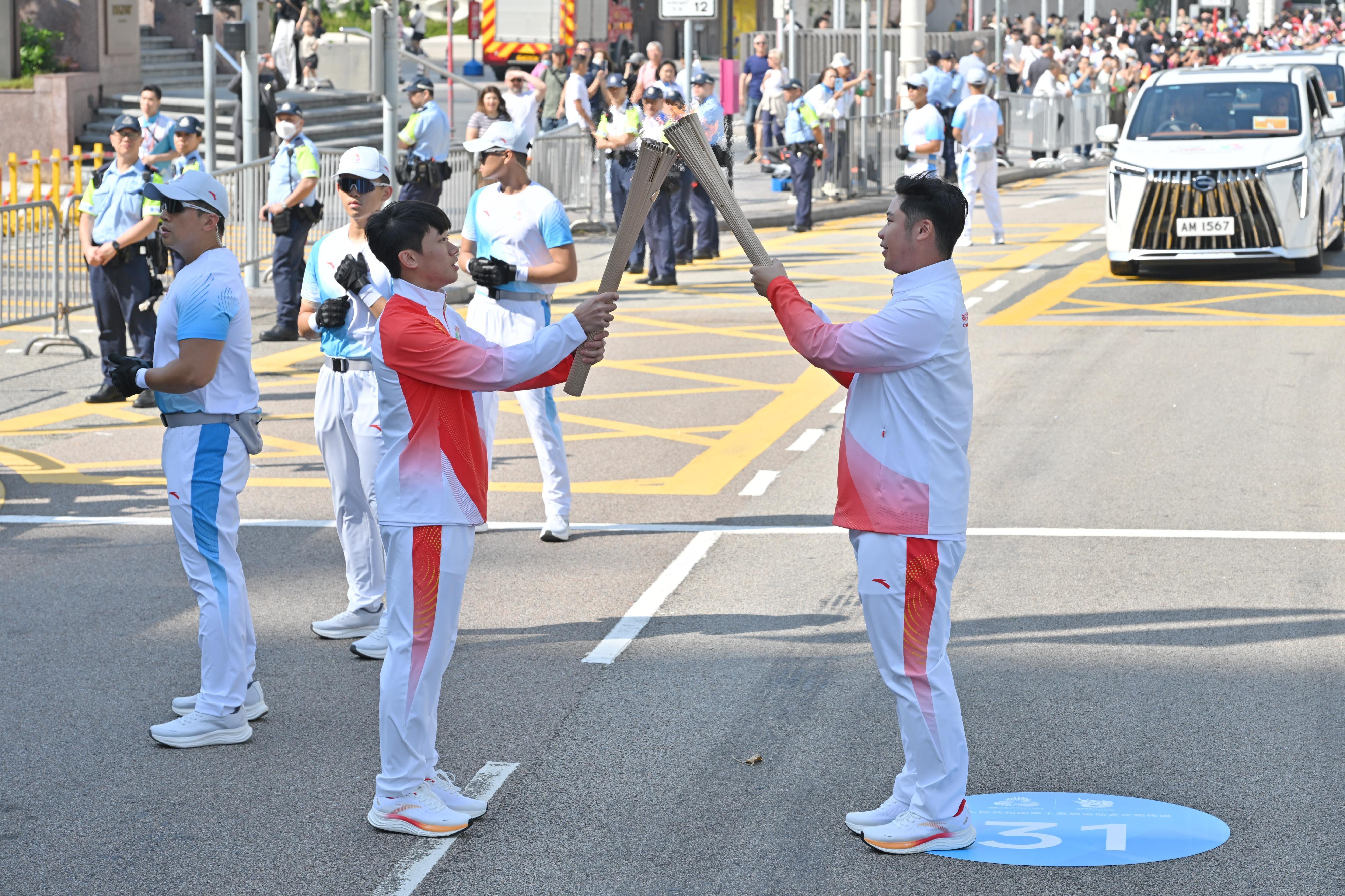 蘇熙驊（右）把火種傳給廖曉朗（左）。