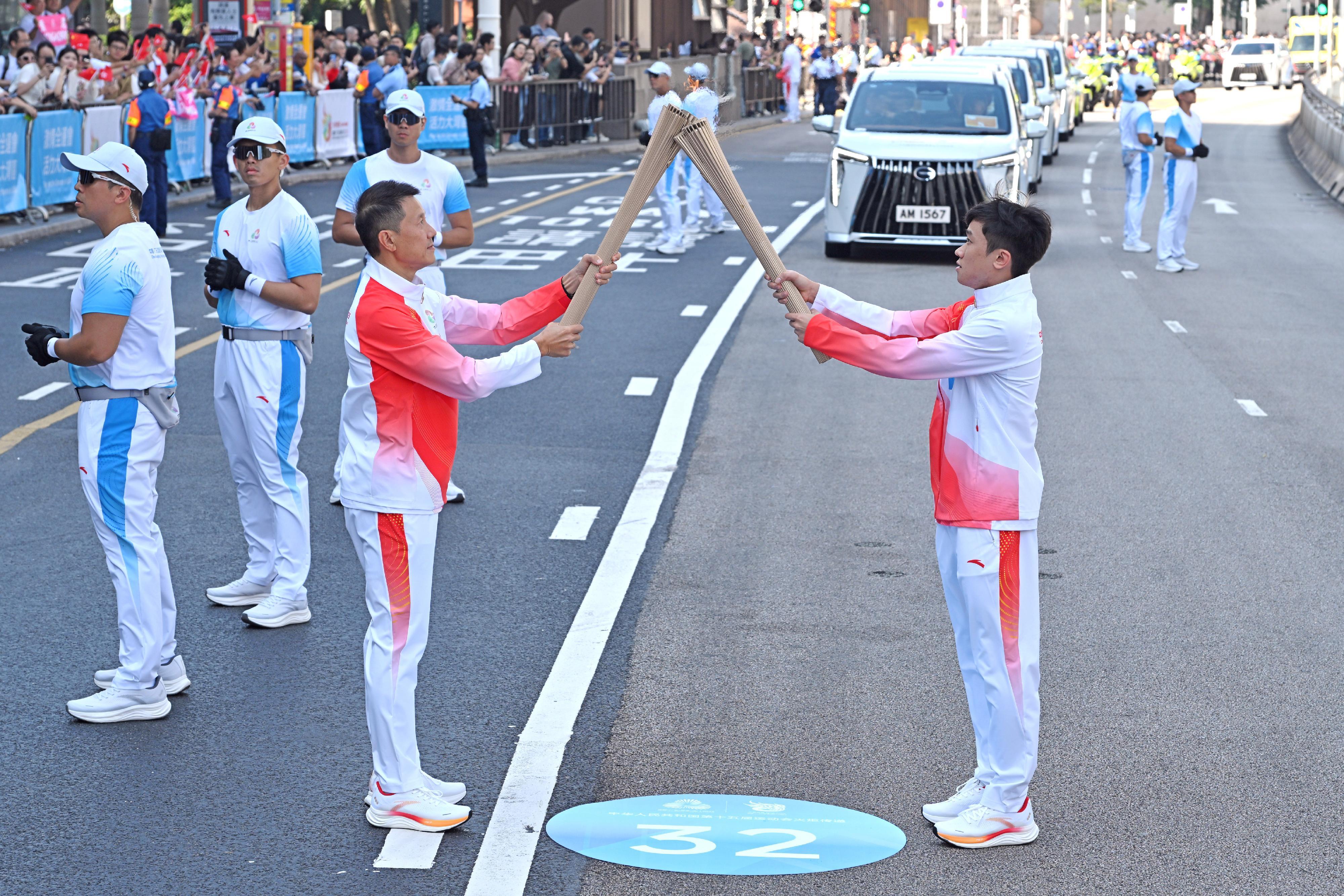 廖曉朗（右）把火種傳給聶偉文（左）。