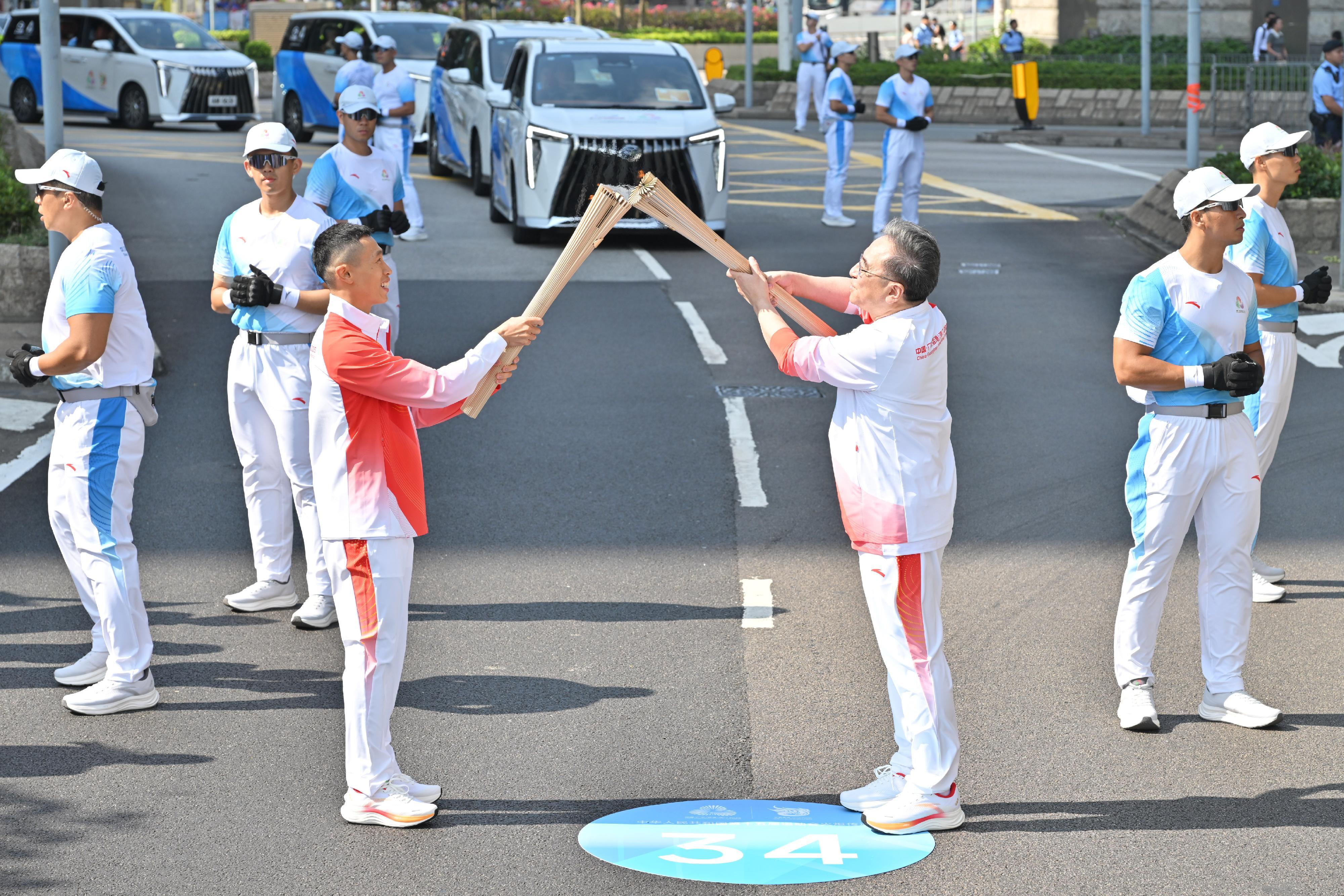 金澤培（右）把火種傳給何澤堯（左）。