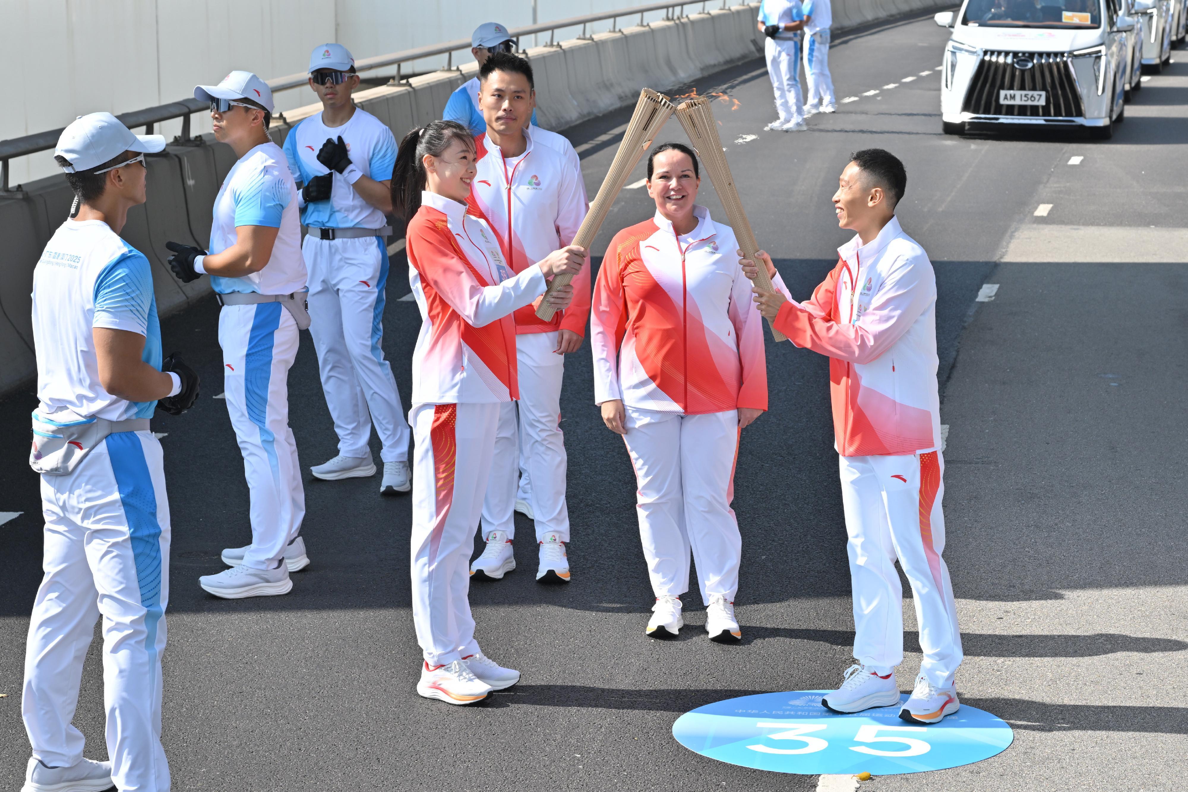 何澤堯（右一）把火種傳給丁欣怡（左四）。