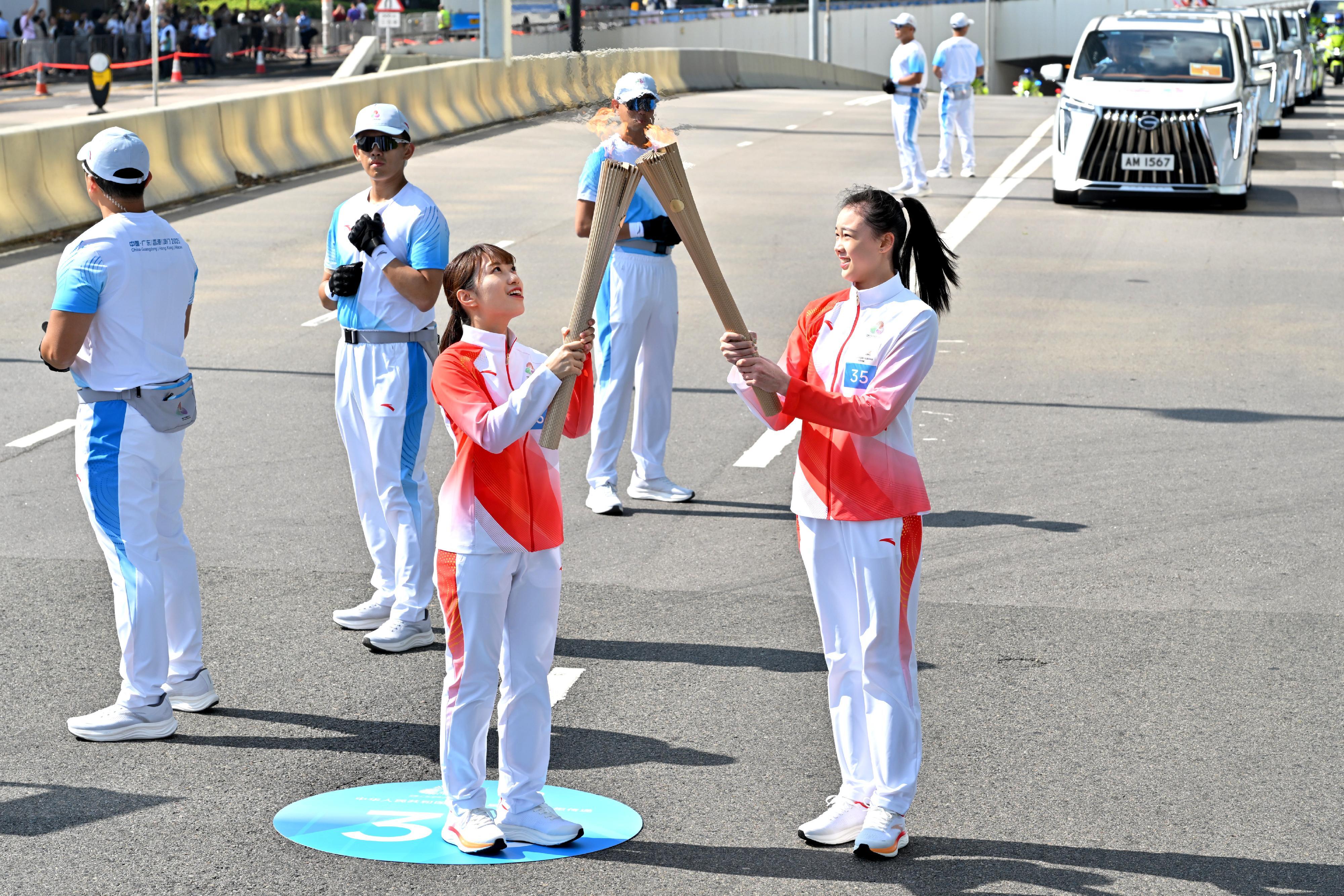 丁欣怡（右）把火種傳給陳欣怡（左）。