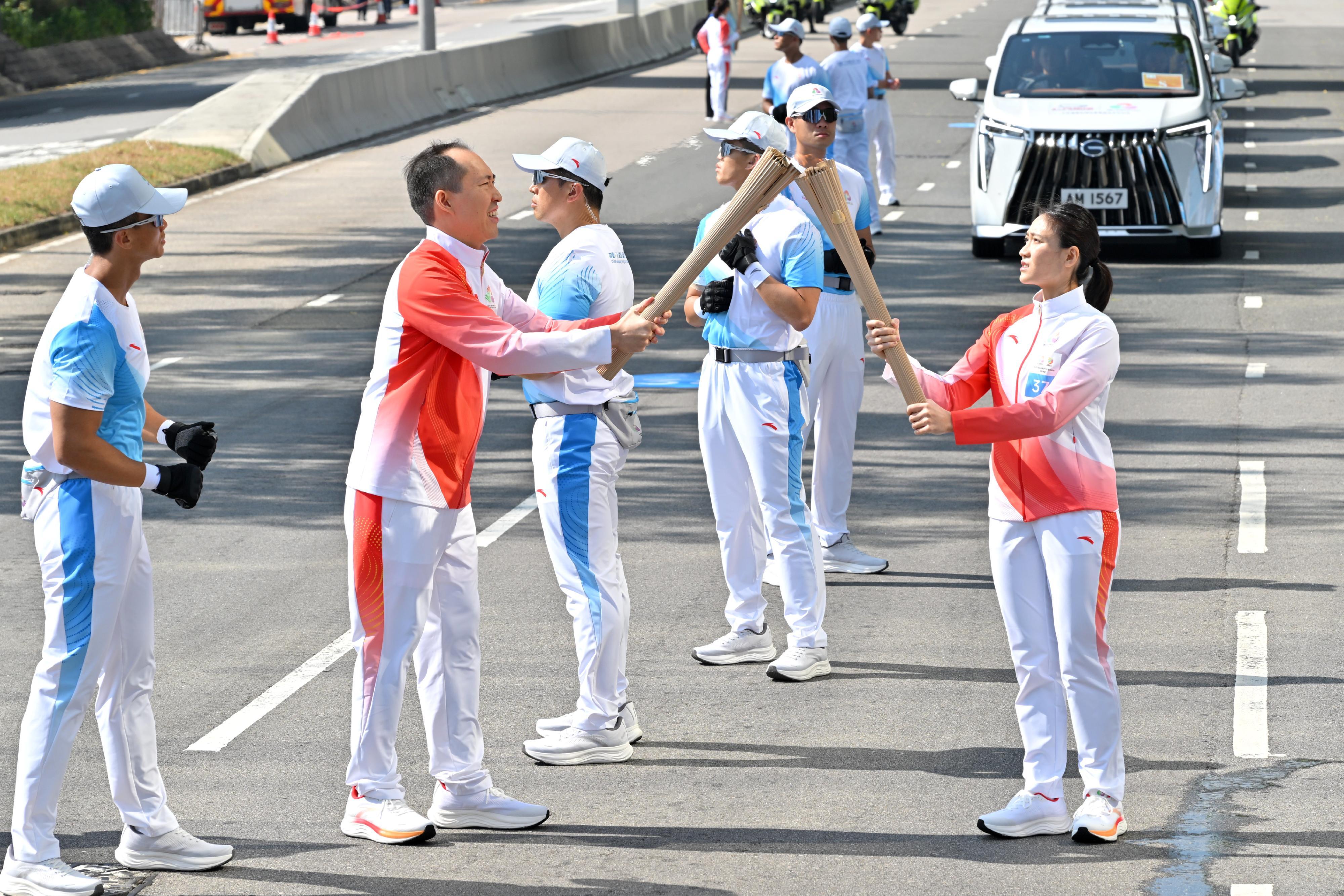梁芝榕（右）把火種傳給黃永光（左）。