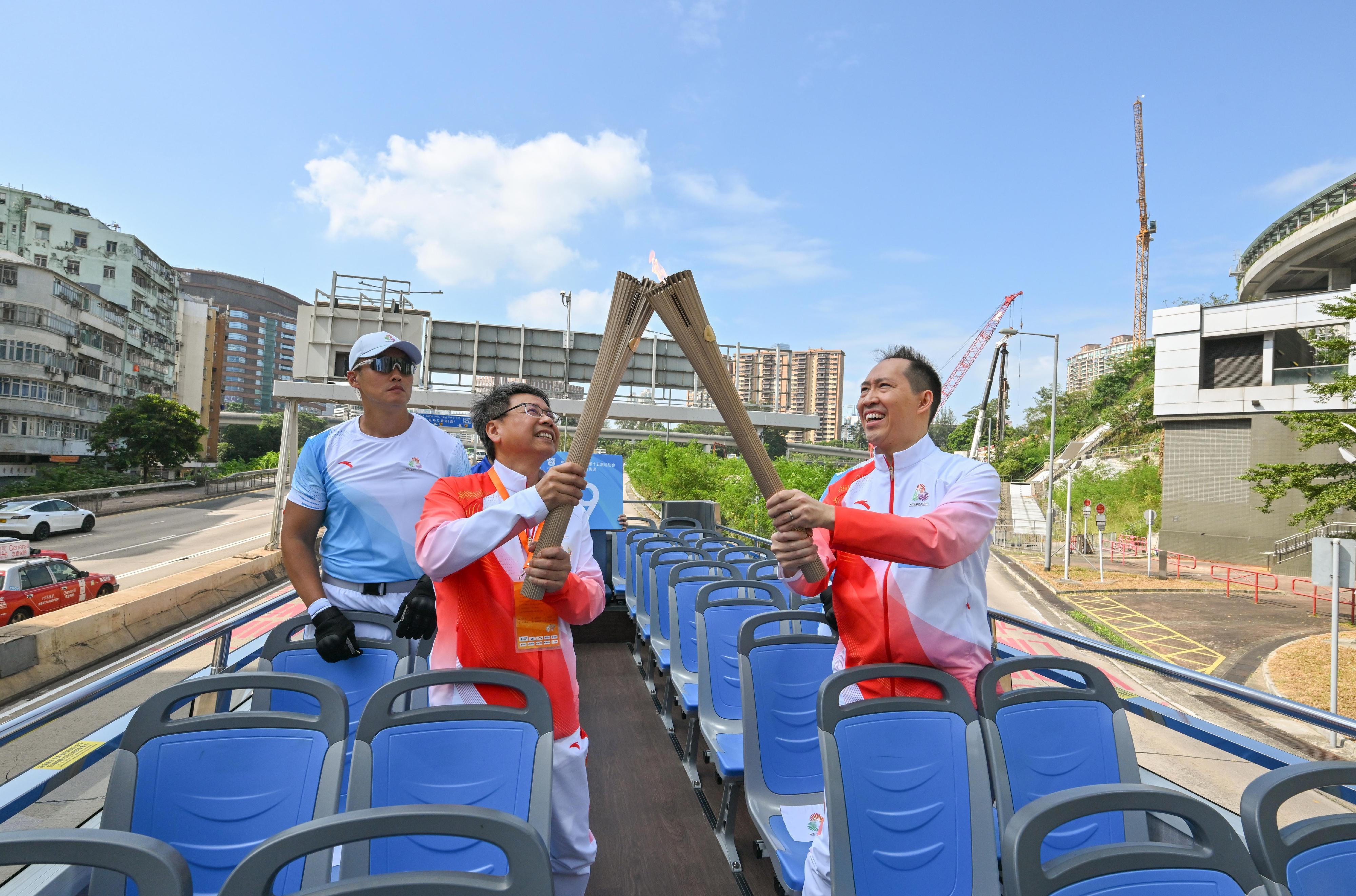 黃永光（右）把火種傳給鍾澤文（左）。