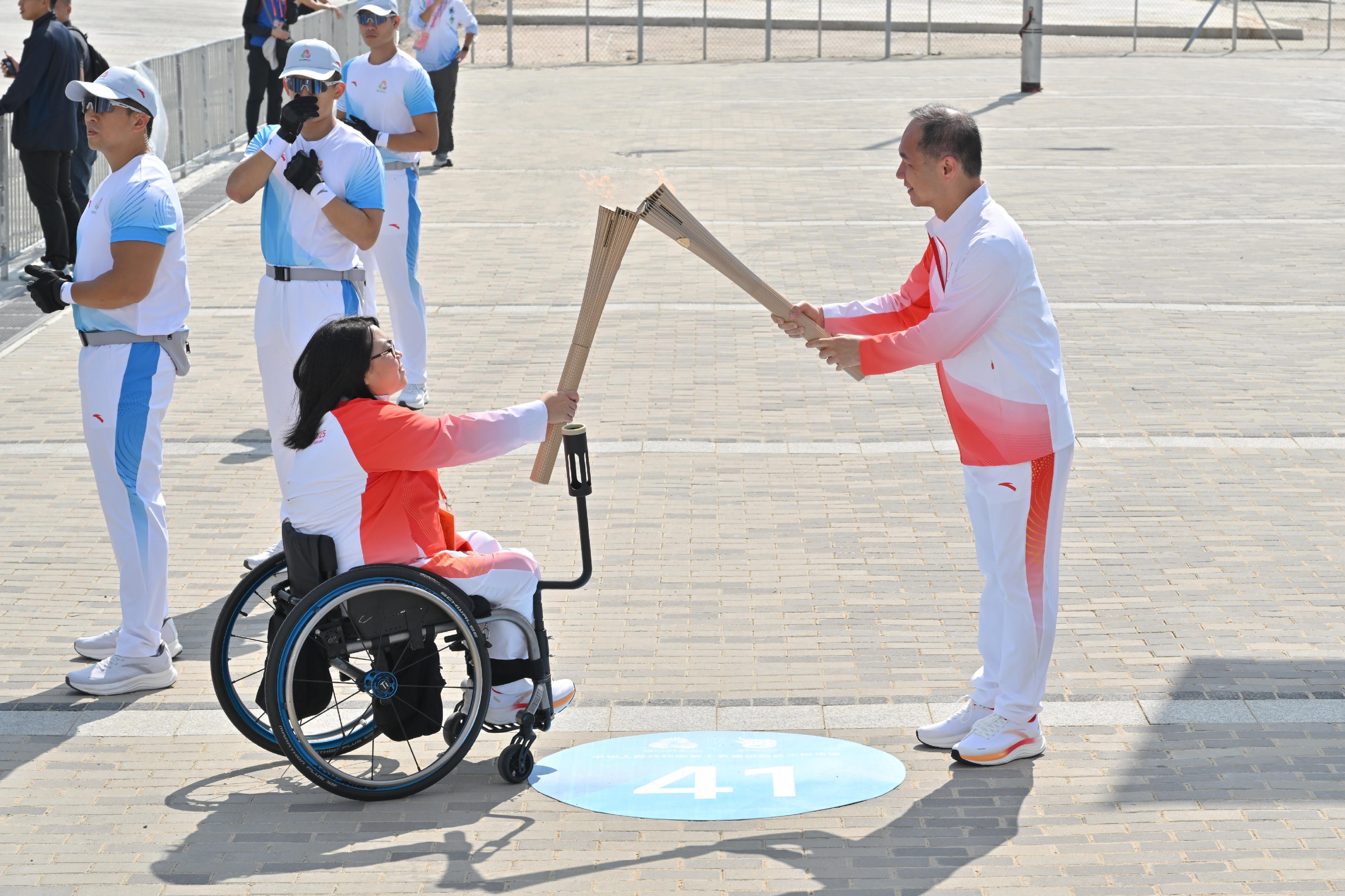 蔣東強（右）把火種傳給呂慧翔（左）。