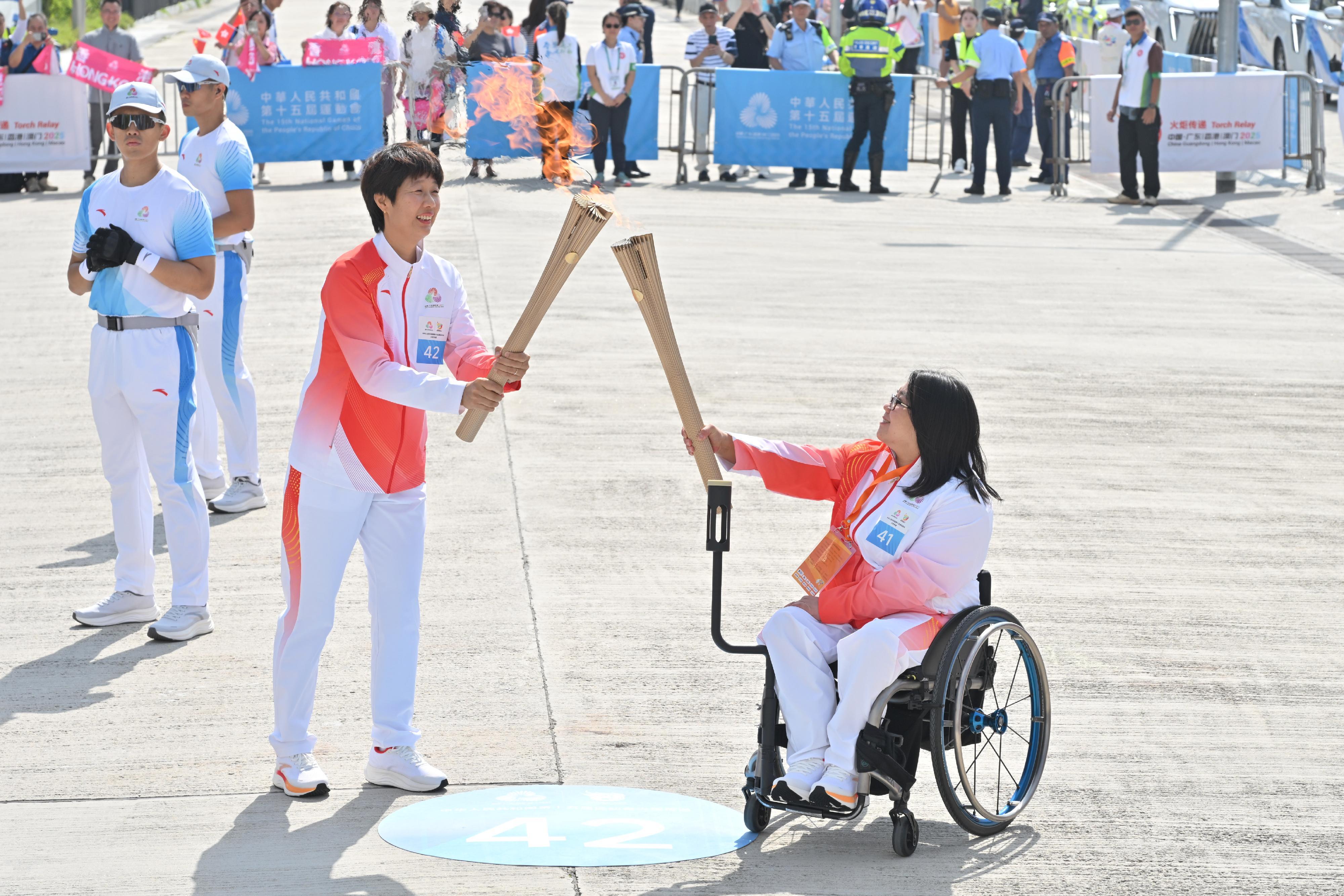 呂慧翔（右）把火種傳給孫甜甜（左）。