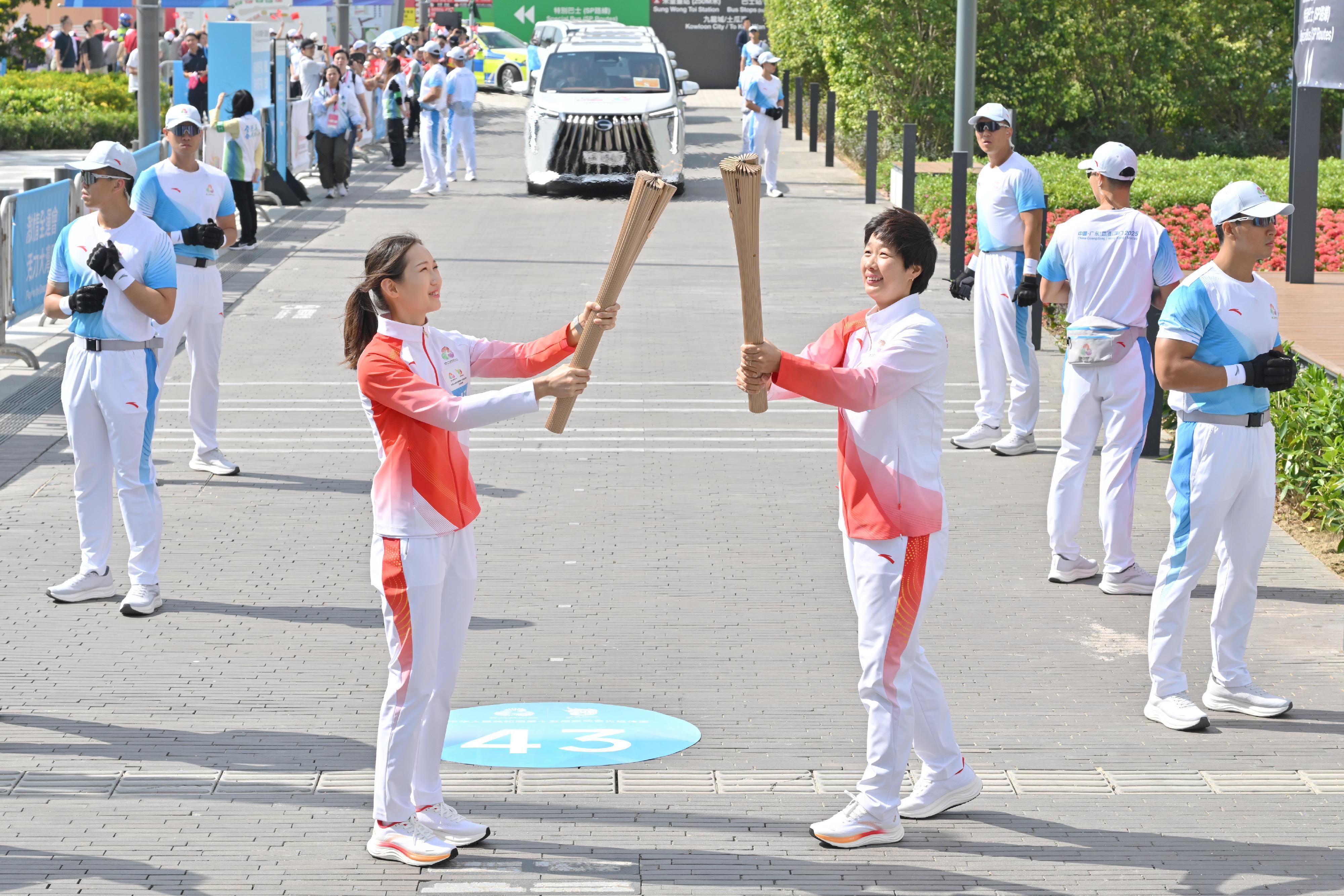 孫甜甜（右）把火種傳給謝苡琳（左）。