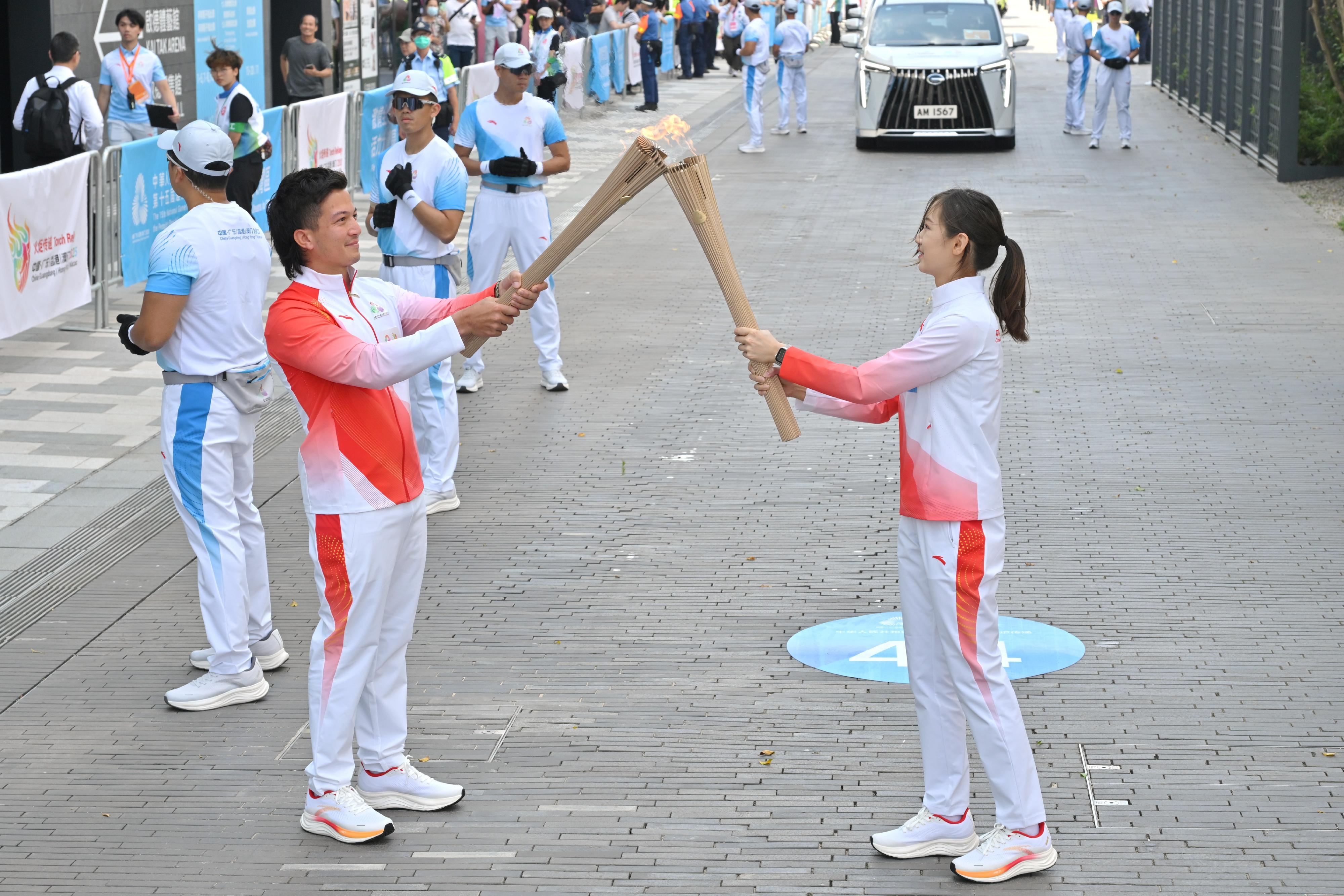 謝苡琳（右）把火種傳給蔡紀駿（左）。