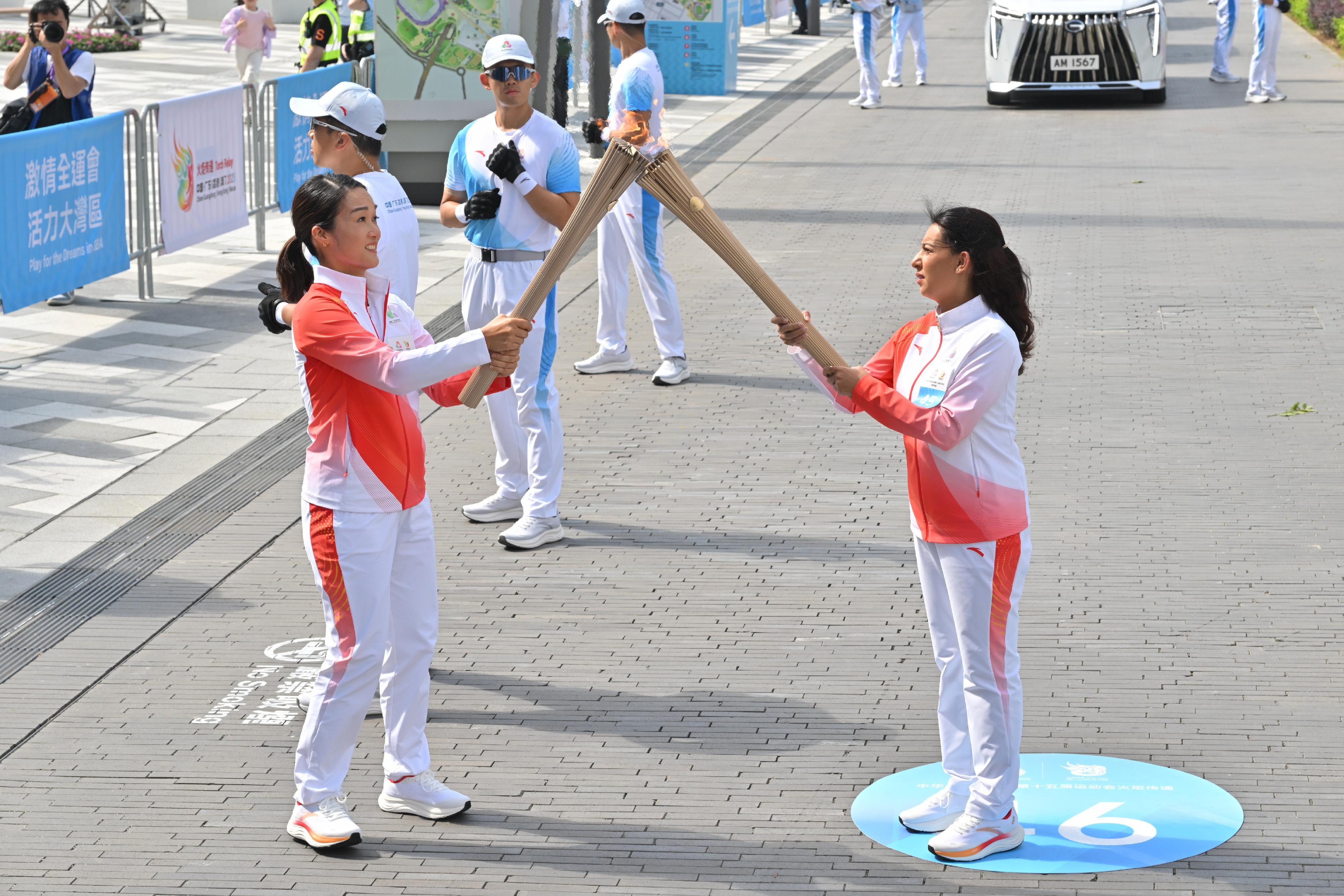 Lamia Sreya Rahman（右）把火種傳給鄭志雯（左）。