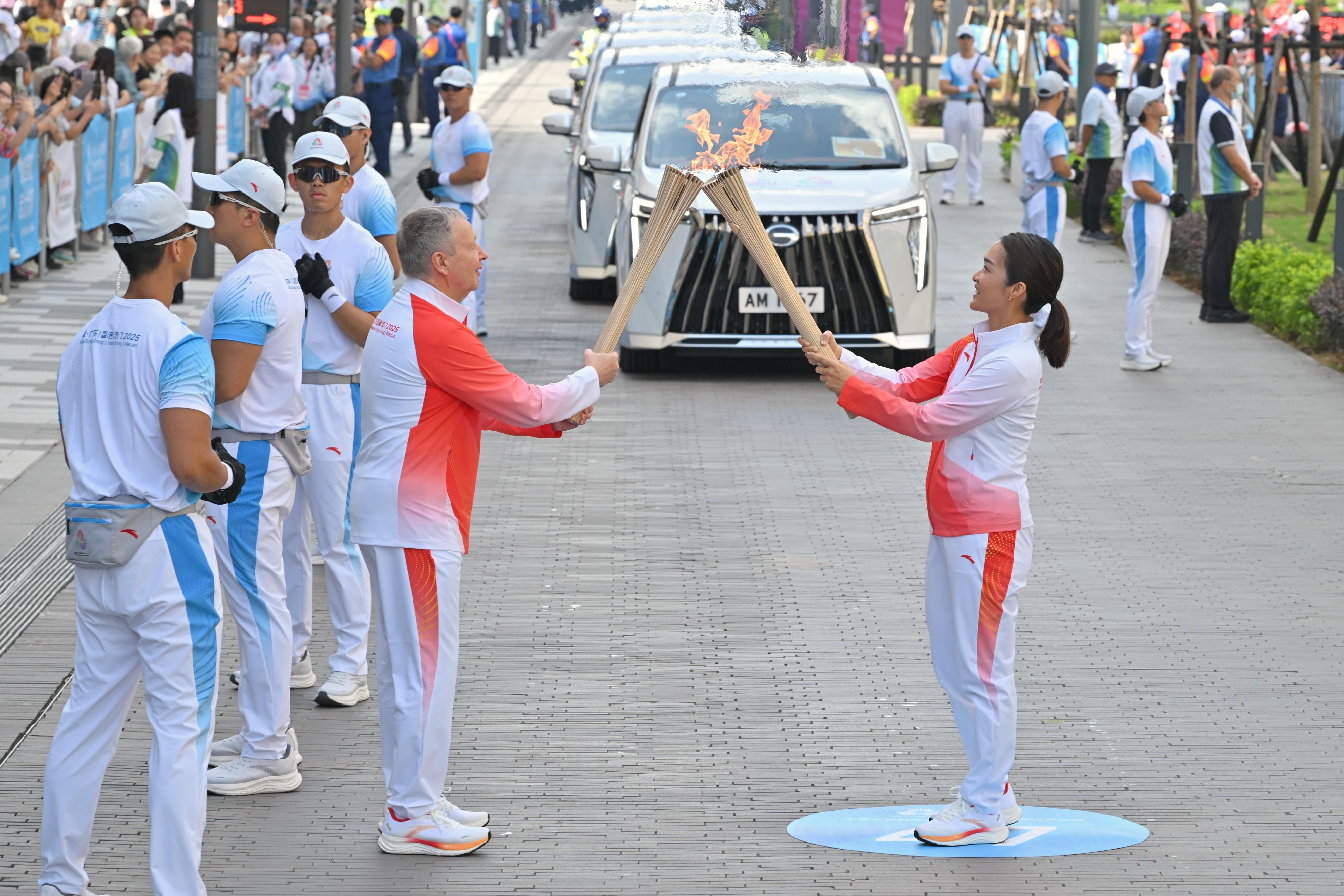 鄭志雯（右）把火種傳給應家柏（左）。