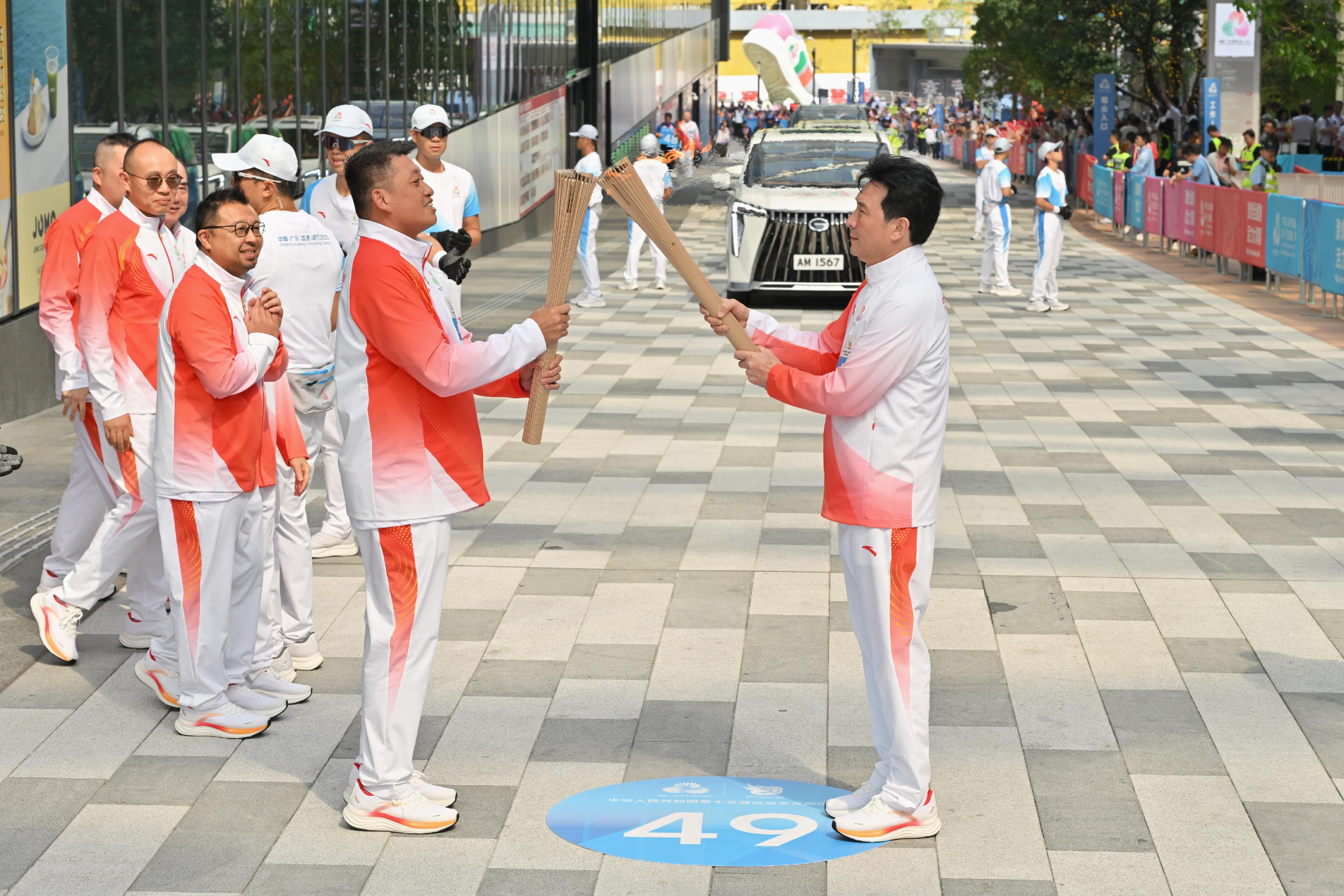 鄭兆康（前排右）把火種傳給梁國成（前排左）。