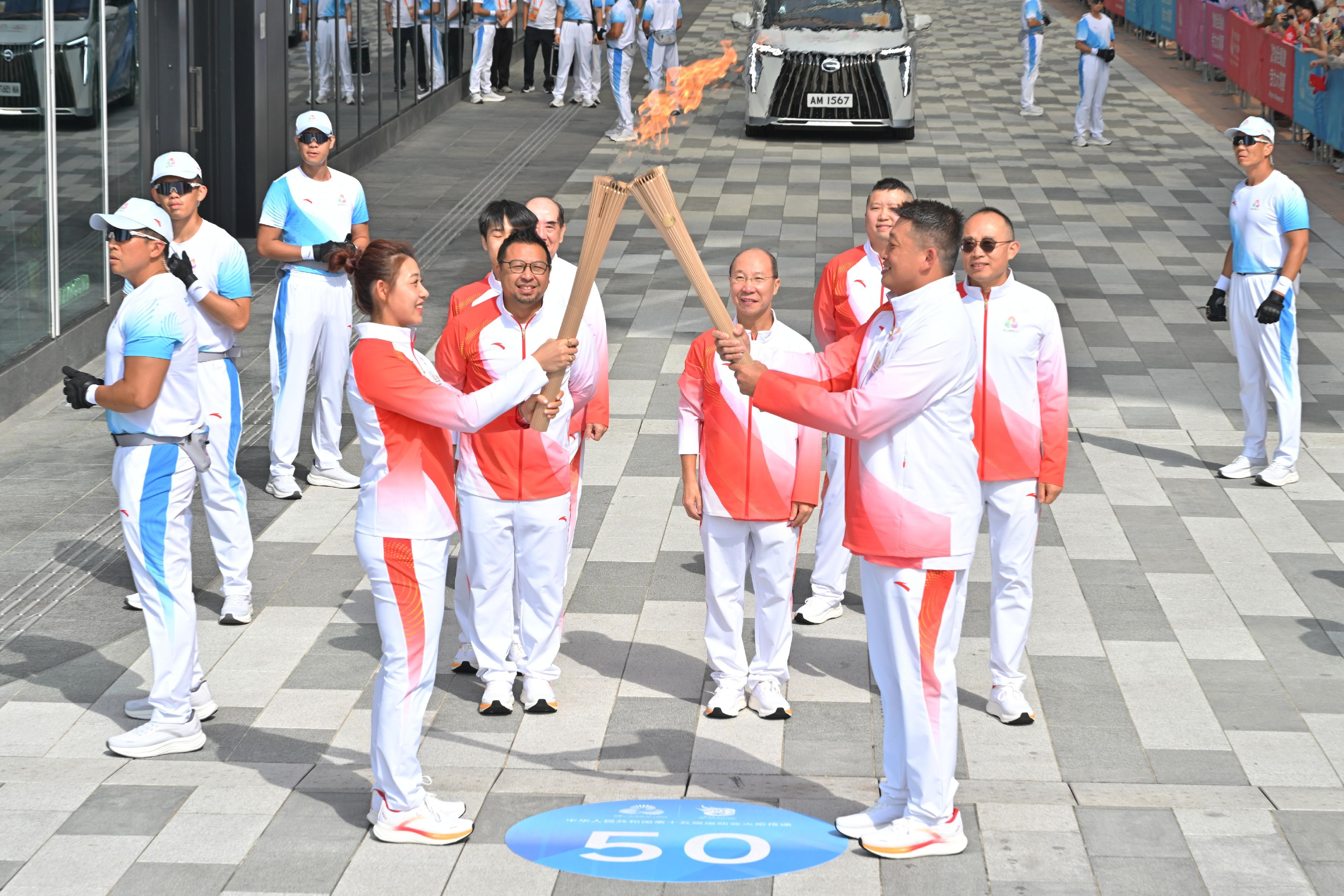 梁國成（前排右）把火種傳給佘繕妡（前排左）。