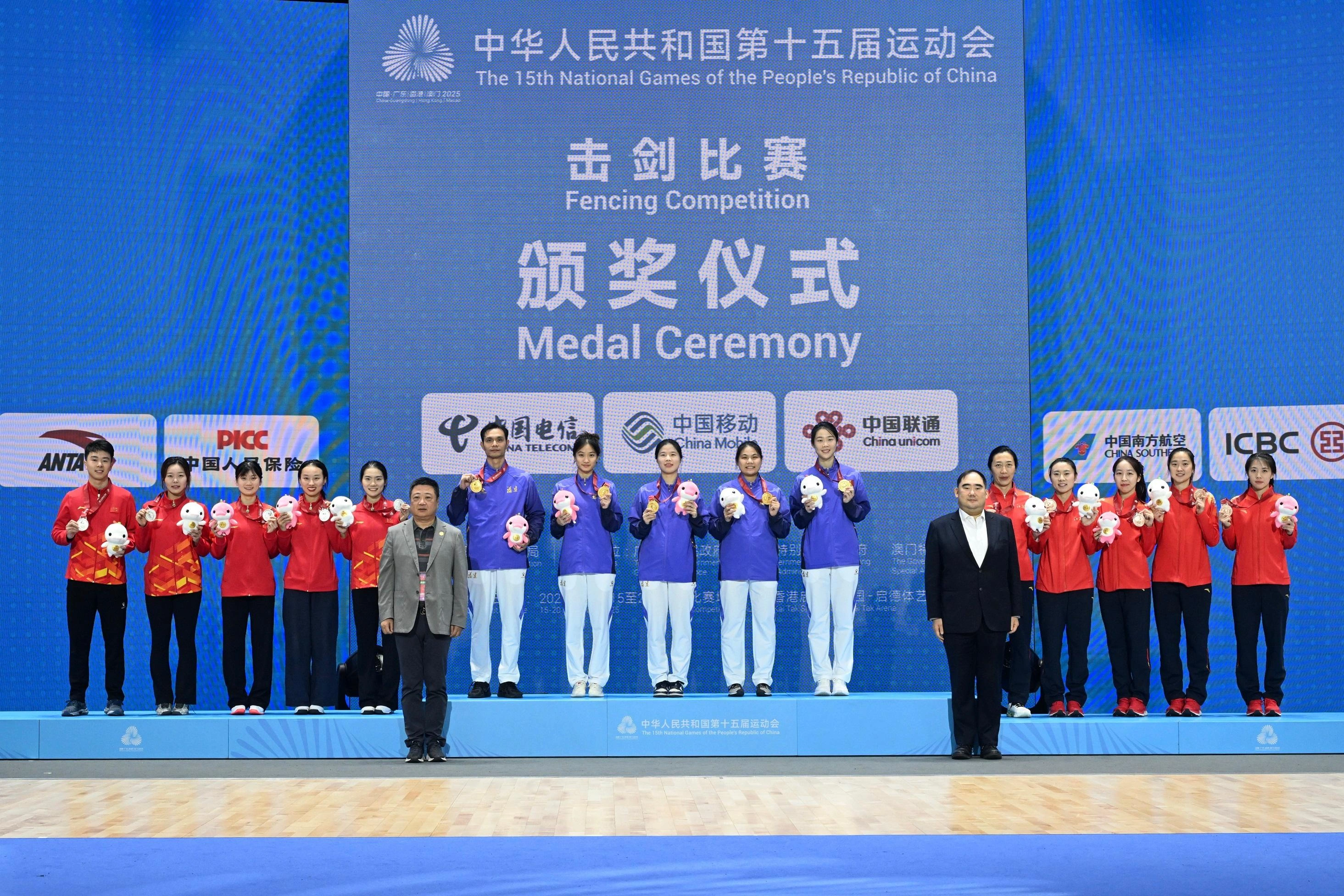 The Women's Foil Team of the fencing competition of the 15th National Games was held on November 20. Photo shows the Director of Fujian Strength Sports Management Centre, Mr Yuan Zunhui (front row, left), and the President of the Fencing Association of Hong Kong, China, Mr Aaron Ng (front row, right), with gold medalists Fujian Team (back row, centre), silver medalists Chongqing Team (back row, left), and bronze medalists Jiangsu Team (back row, right).