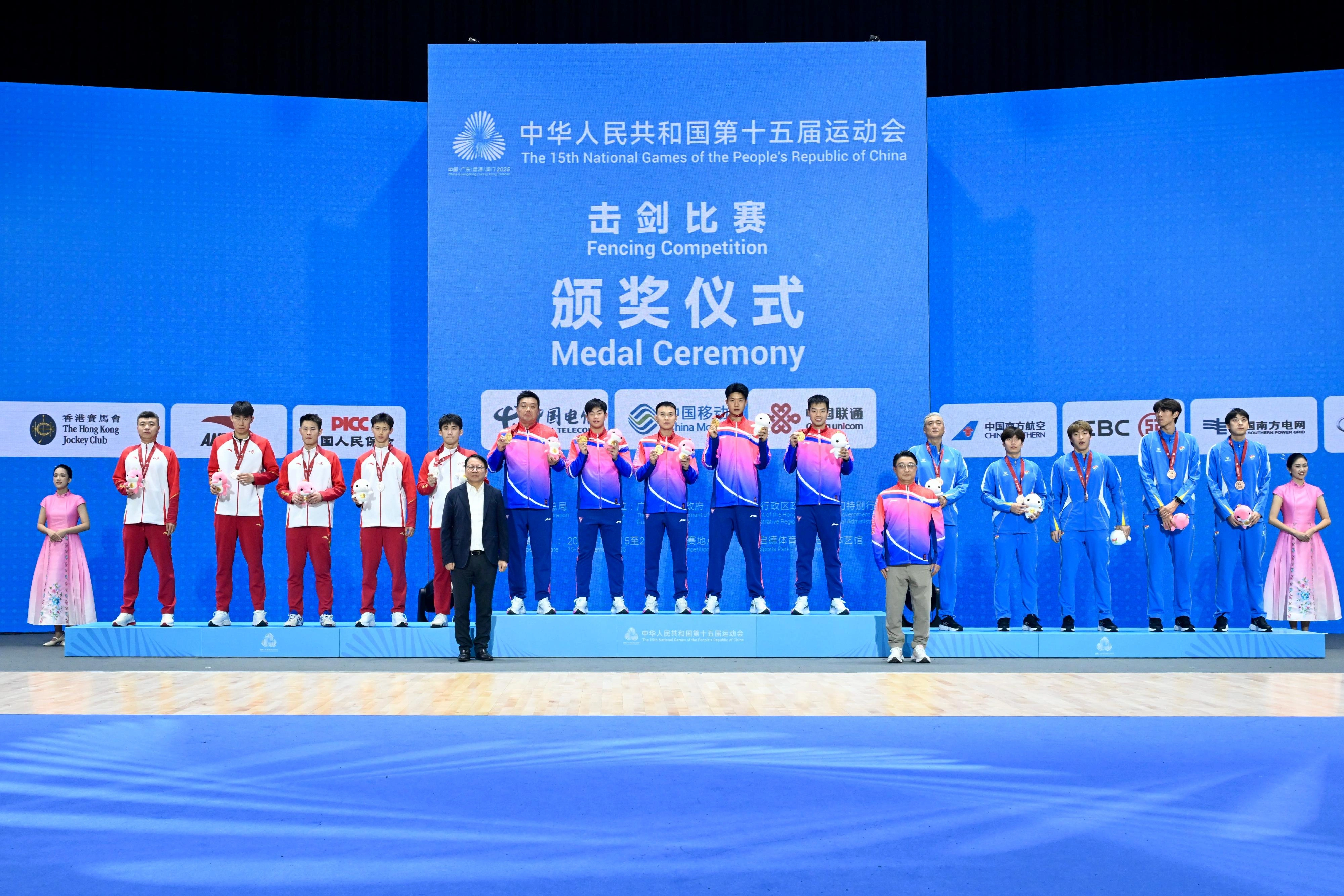 The Men's Épée Team of the fencing competition of the 15th National Games was held on November 20. Photo shows the Chief Secretary for Administration, Mr Chan Kwok-ki (front row, left), and the Deputy Director of the Shanghai Administration of Sports, Mr Lu Lin (front row, right), with gold medalists Shanghai Team (back row, centre), silver medalists Shandong Team (back row, left), and bronze medalists Liaoning Team (back row, right).