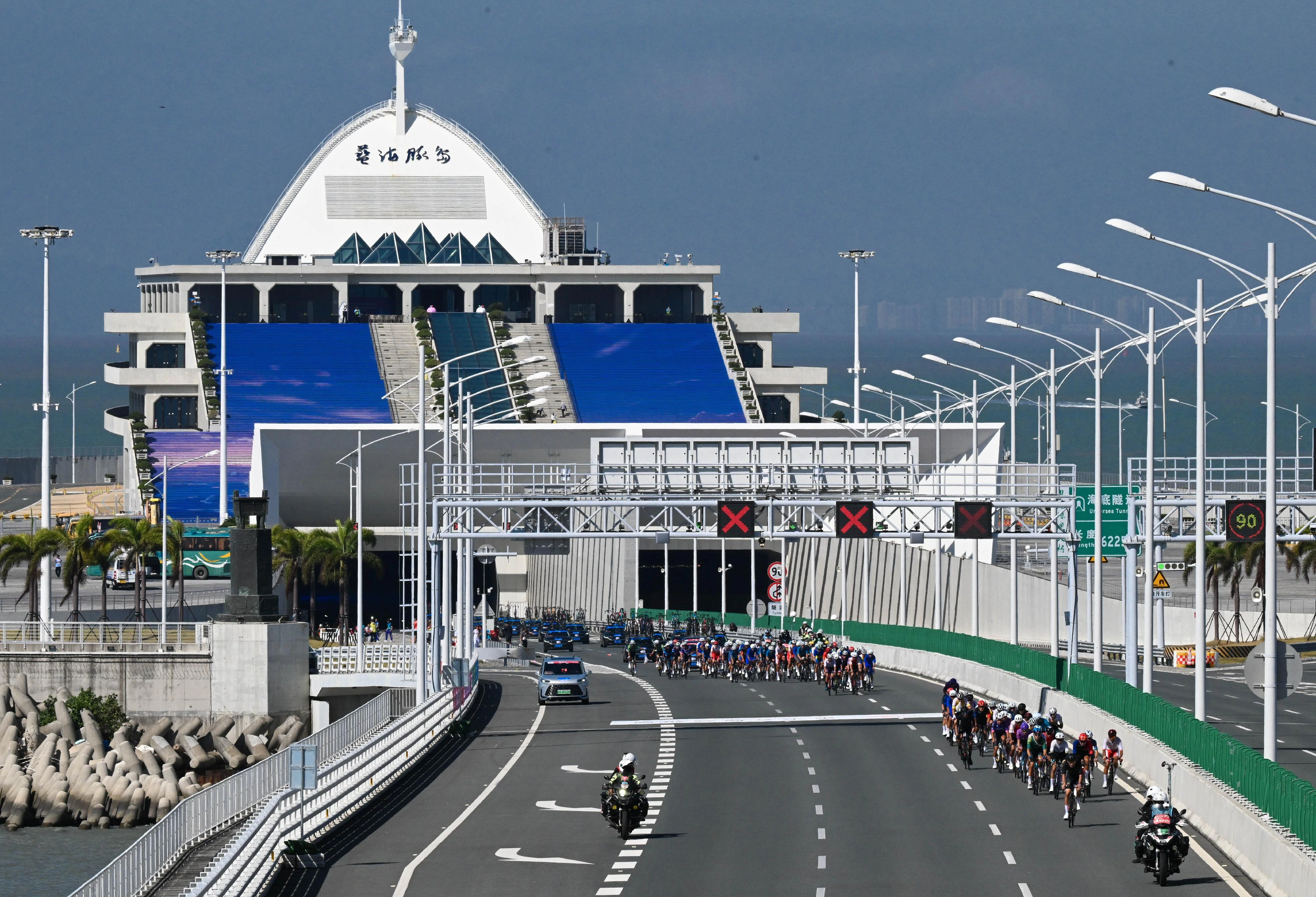 第十五届全国运动会「中国移动盃」自行车（公路）比赛的男子个人赛十一月八日在珠海、香港、澳门三地城市道路和港珠澳大桥举行。图示参赛选手经港珠澳大桥进入香港赛段作赛。