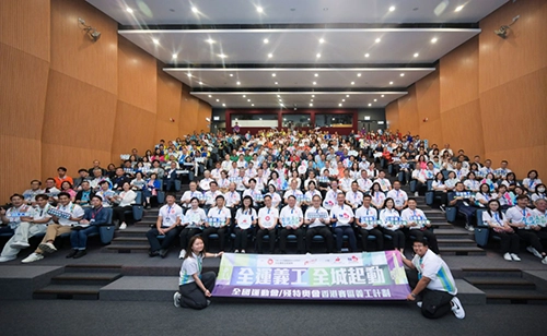 一組政府官員坐在房間內，手持全國運動會志願者工作的橫幅
