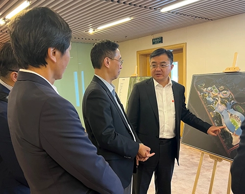 幾名政府官員圍在一起查看場地的概念設計